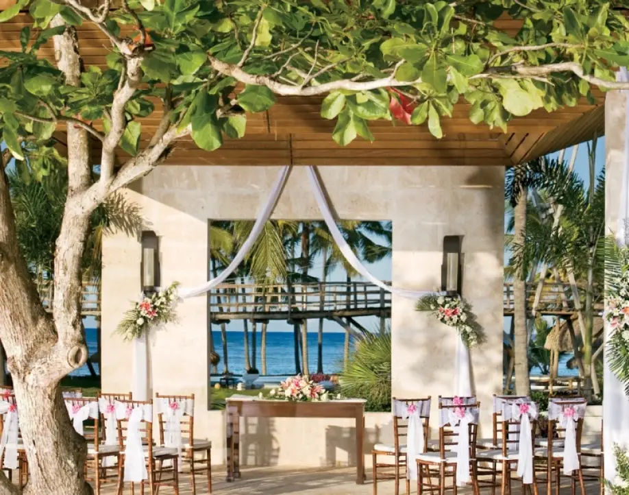 Wedding ceremony setup with floral pillars and white drapery at Zoetry Agua Punta Cana, Miches