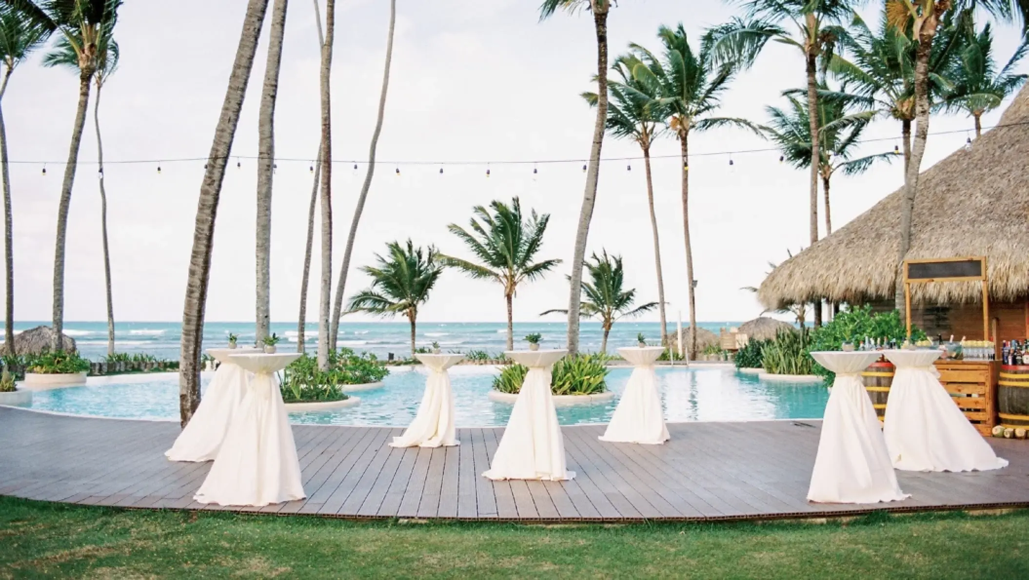 Poolside wedding reception setup with cocktail tables at Zoetry Agua, Punta Cana