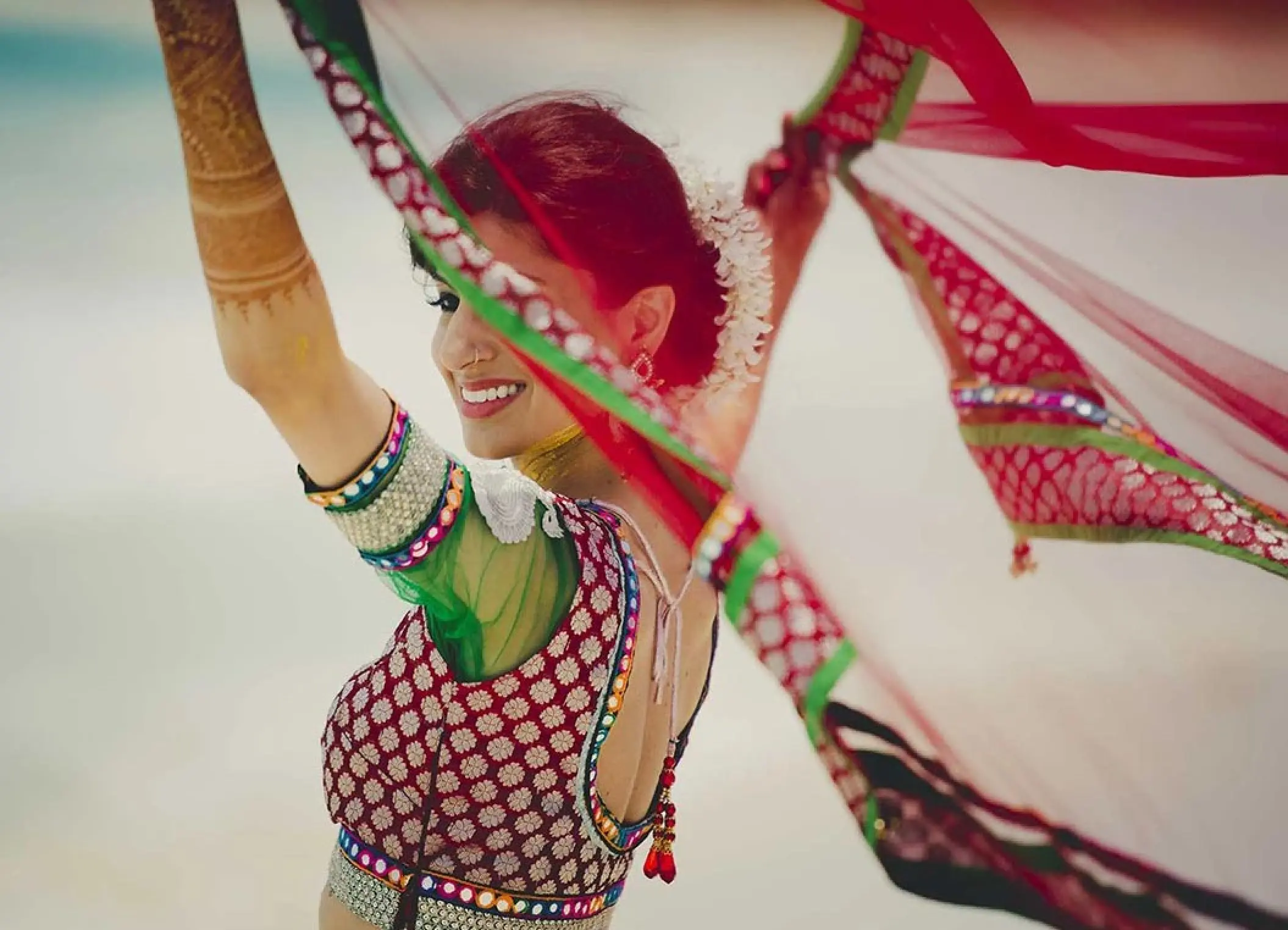 South Asian bride dancing on the beach during a wedding at Zoetry Agua Punta Cana