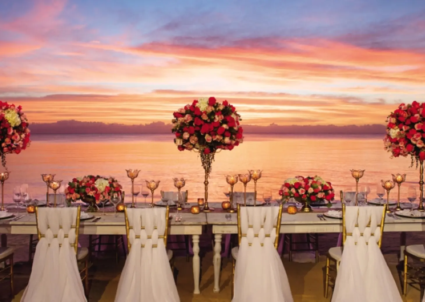 Beachfront wedding reception setup with floral centerpieces at sunset, Zoetry Casa del Mar, Cabo San Lucas