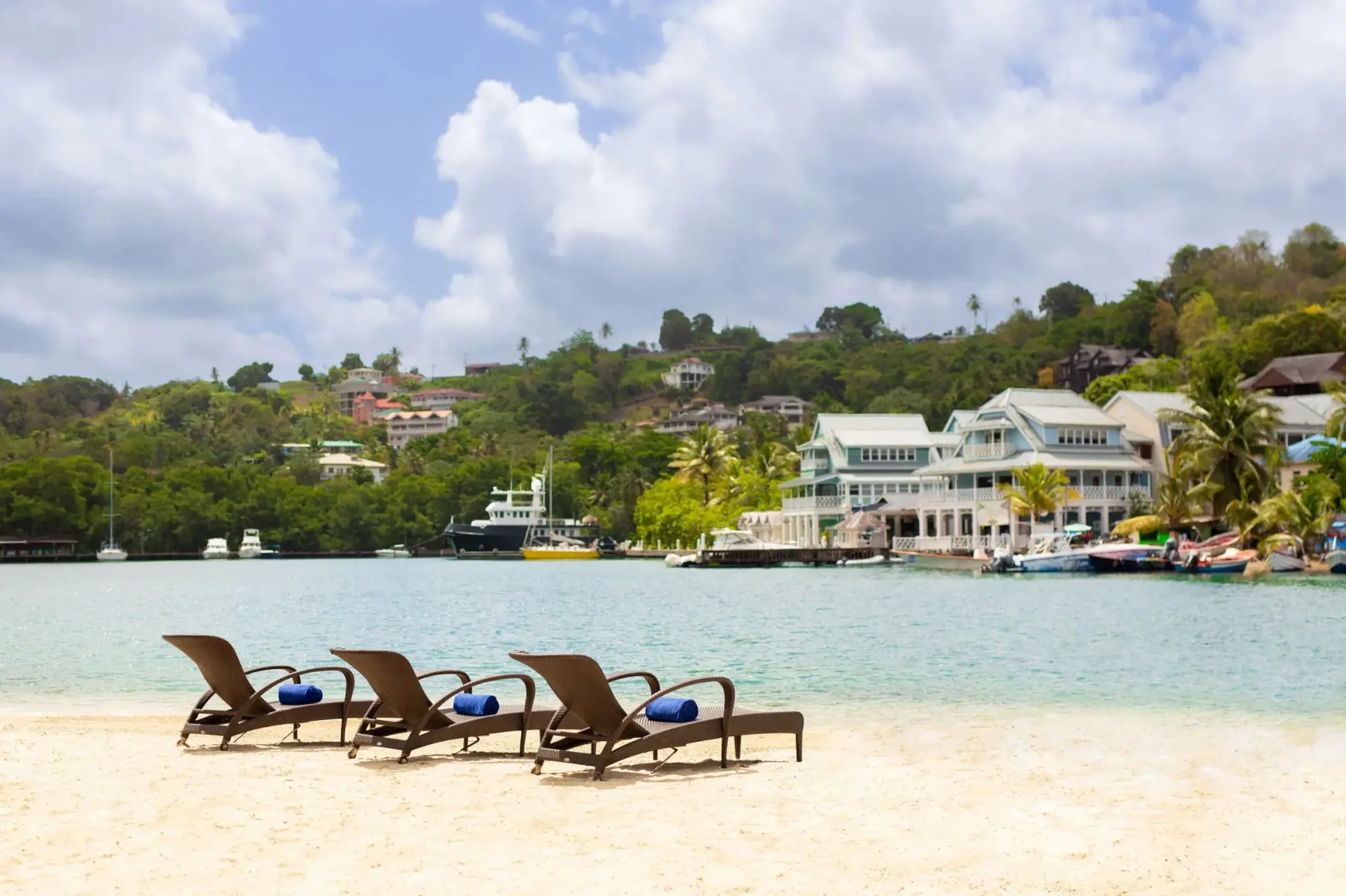 Lounge chairs on the beach at Zoëtry Marigot Bay overlooking the marina and hillside, Castries