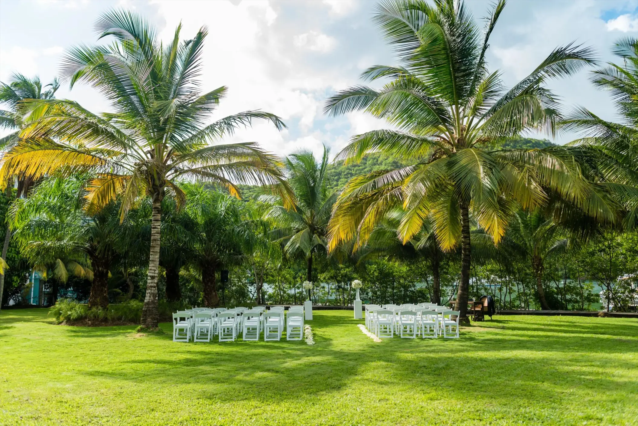 Palm Pavilion lawn wedding ceremony with white chairs at Zoetry Marigot Bay, Castries