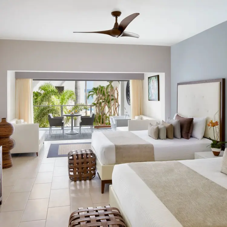 Junior Suite Ocean View guest room with two beds and a balcony at Zoetry Montego Bay