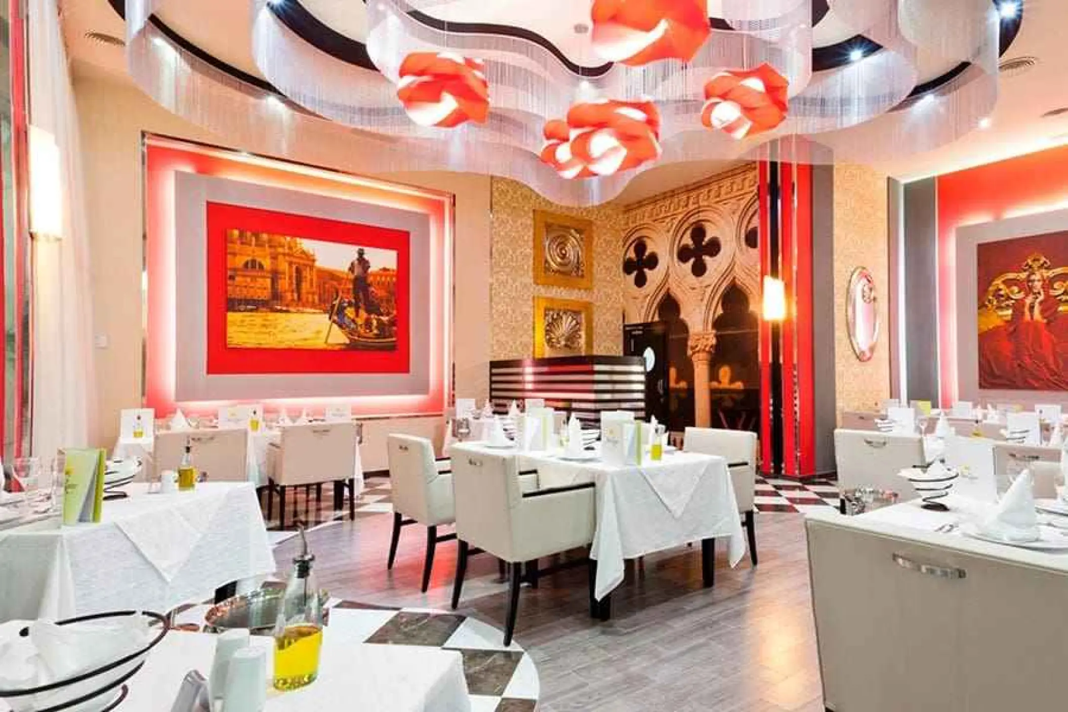 Italian restaurant dining room with white tables and orange ceiling decor at Riu Palace Mexico, Playa Del Carmen