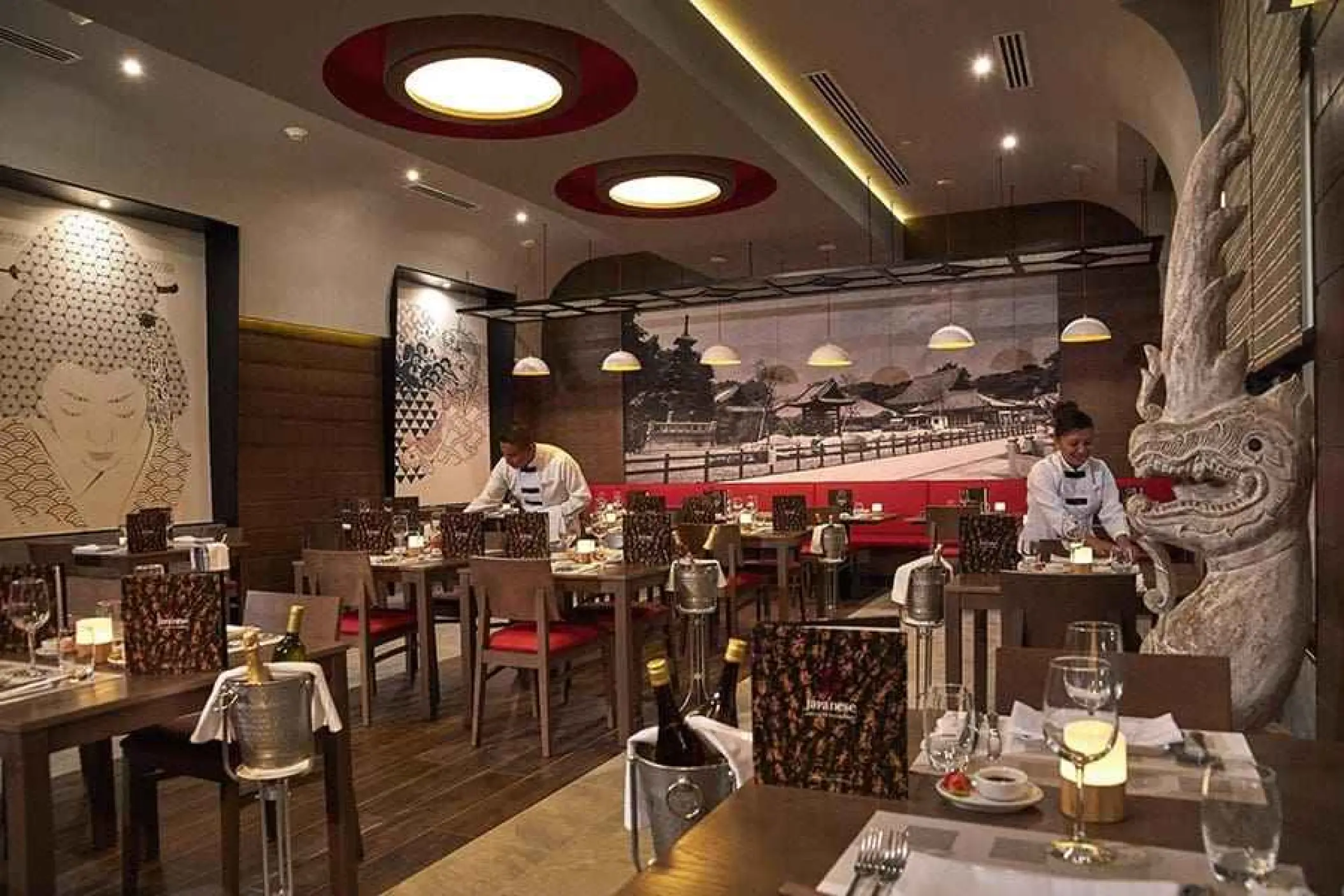 Japanese restaurant interior with servers and large murals at Riu Palace Riviera Maya, Playa Del Carmen
