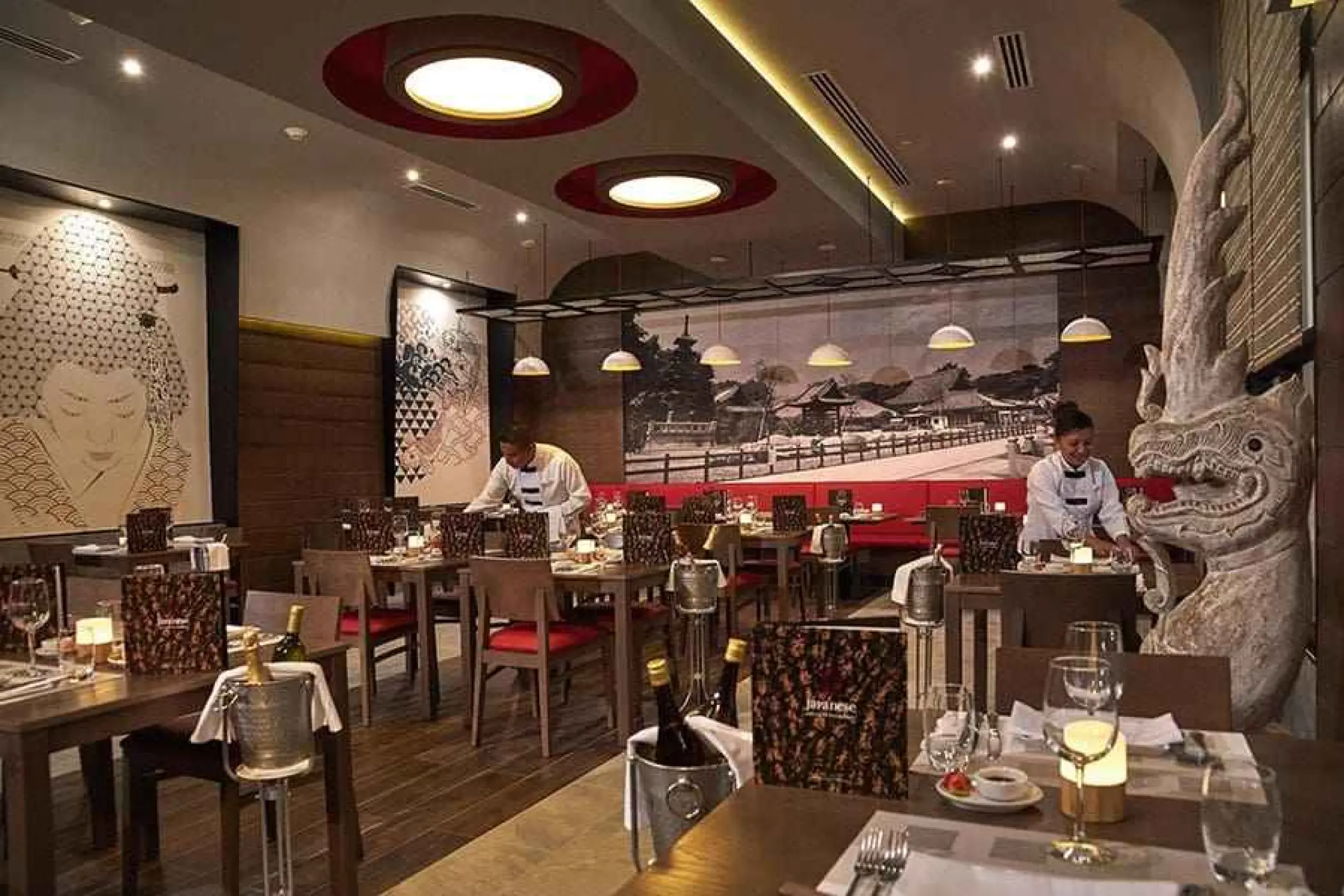 Japanese restaurant interior with servers and large murals at Riu Palace Riviera Maya, Playa Del Carmen