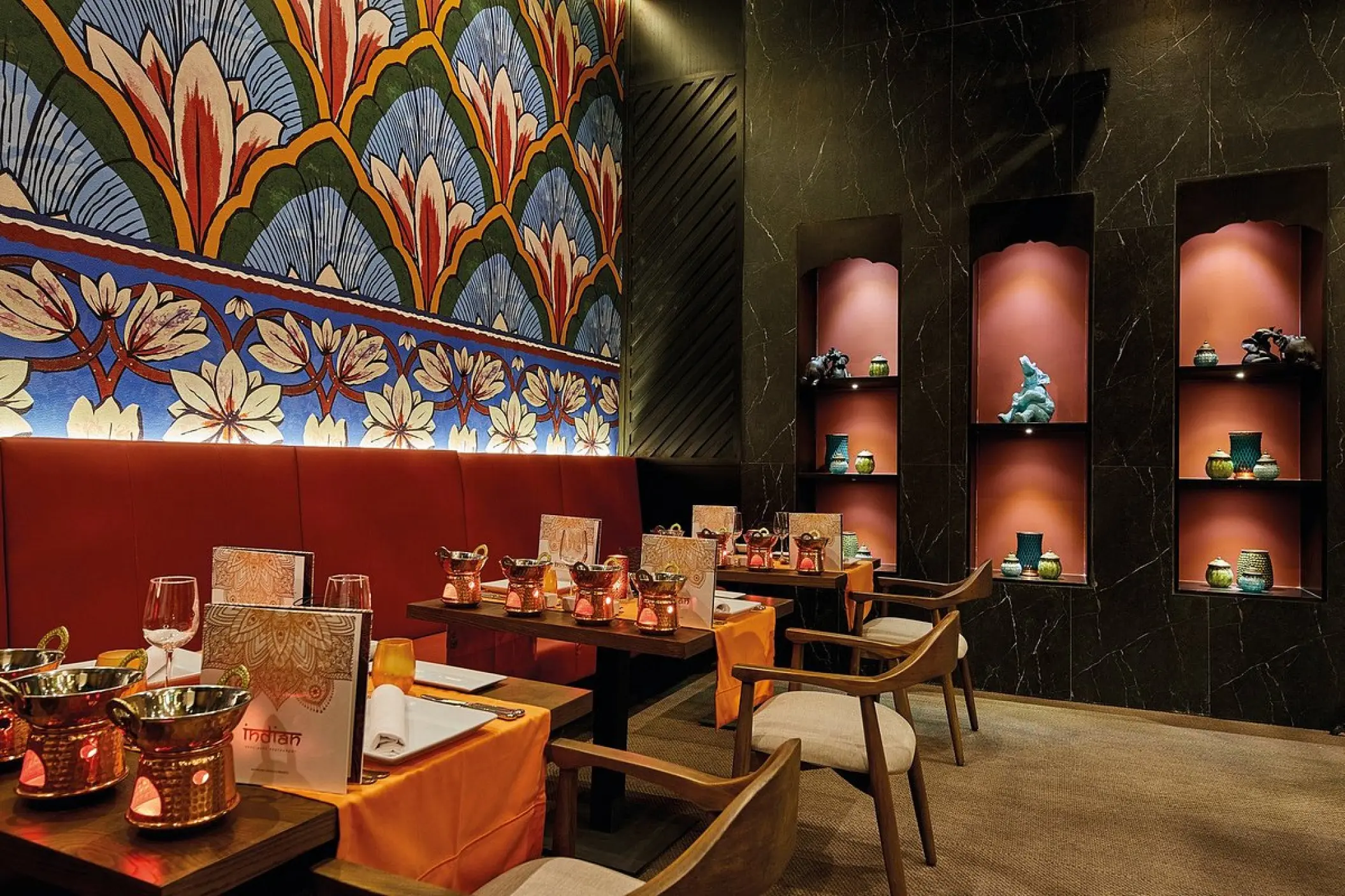 Indian restaurant dining area with patterned wall art and red booth seating at Riu Palace Baja California, Cabo San Lucas