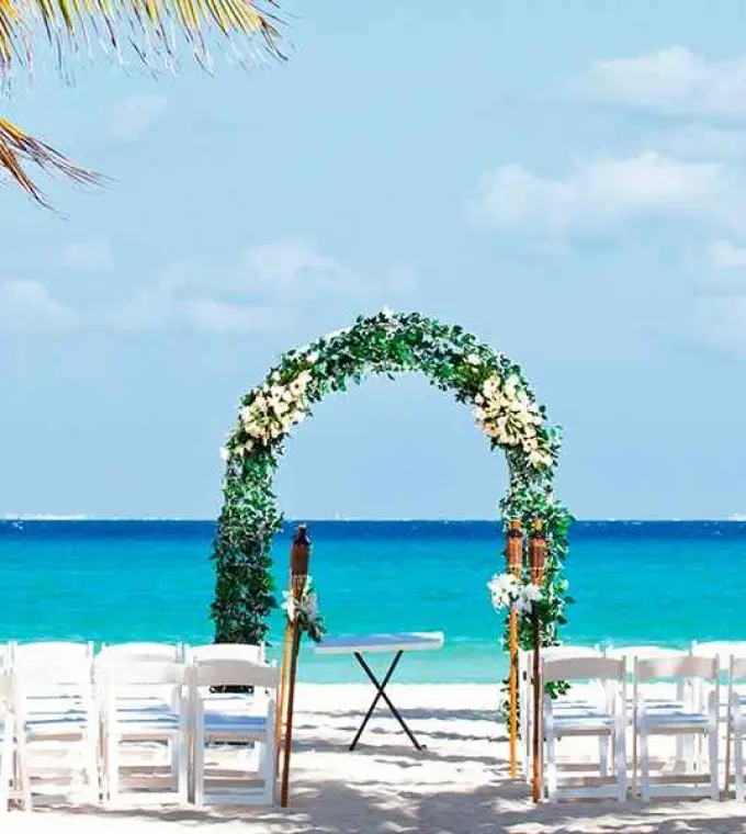 Beachfront wedding ceremony with a floral arch at Riu Palace Mexico, Playa Del Carmen