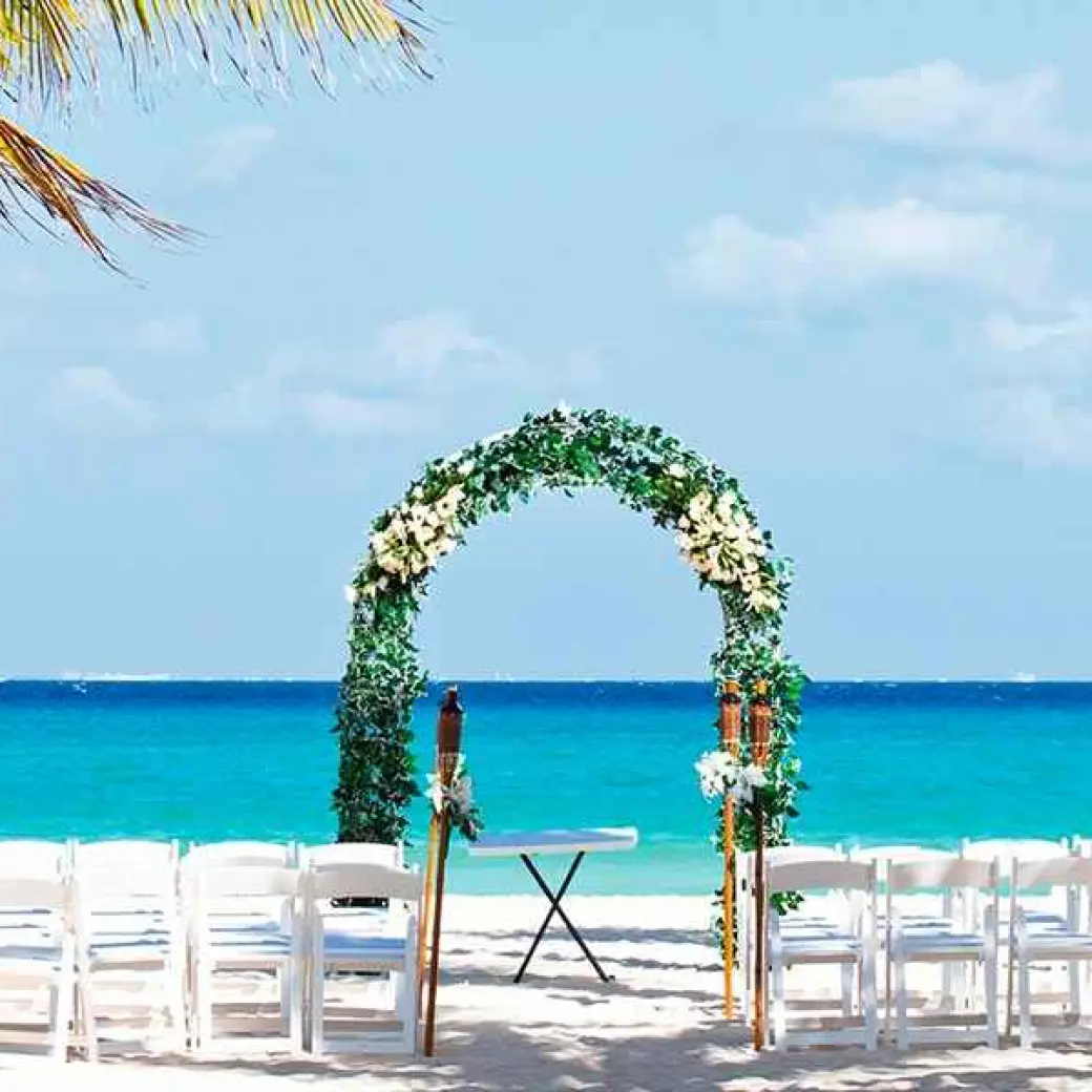 Beachfront wedding ceremony with a floral arch at Riu Palace Mexico, Playa Del Carmen