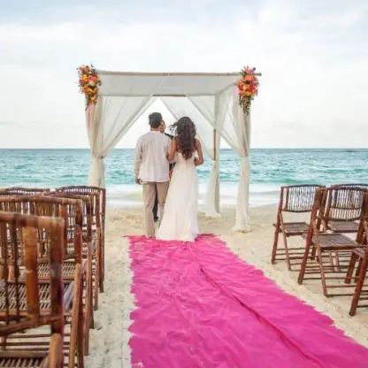 Beachfront wedding ceremony with a pink aisle runner at Riu Yucatan, Playa Del Carmen