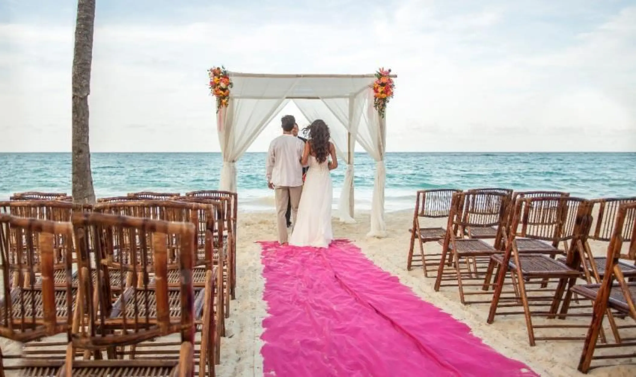 Beachfront wedding ceremony with a pink aisle runner at Riu Yucatan, Playa Del Carmen