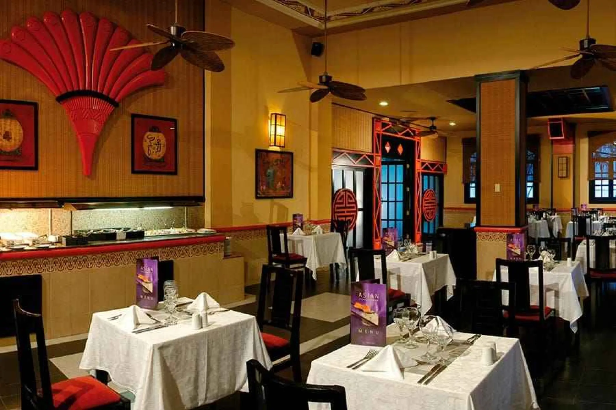 Asian themed specialty restaurant with red fan decor and white tablecloths at Riu Yucatan, Playa Del Carmen