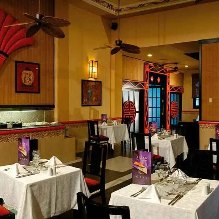 Asian themed specialty restaurant with red fan decor and white tablecloths at Riu Yucatan, Playa Del Carmen