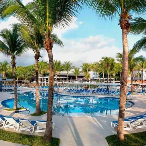 Riu Yucatan outdoor swimming pool surrounded by palm trees and lounge chairs, Playa Del Carmen