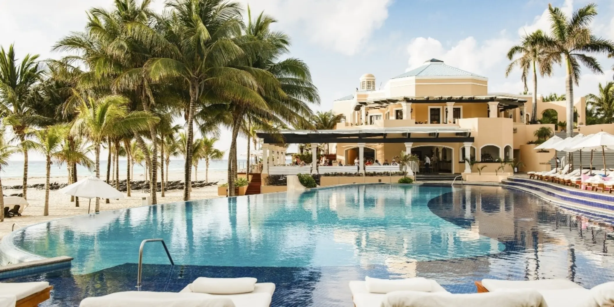 Curving infinity pool and palm trees at Royal Hideaway Playacar, Playa Del Carmen