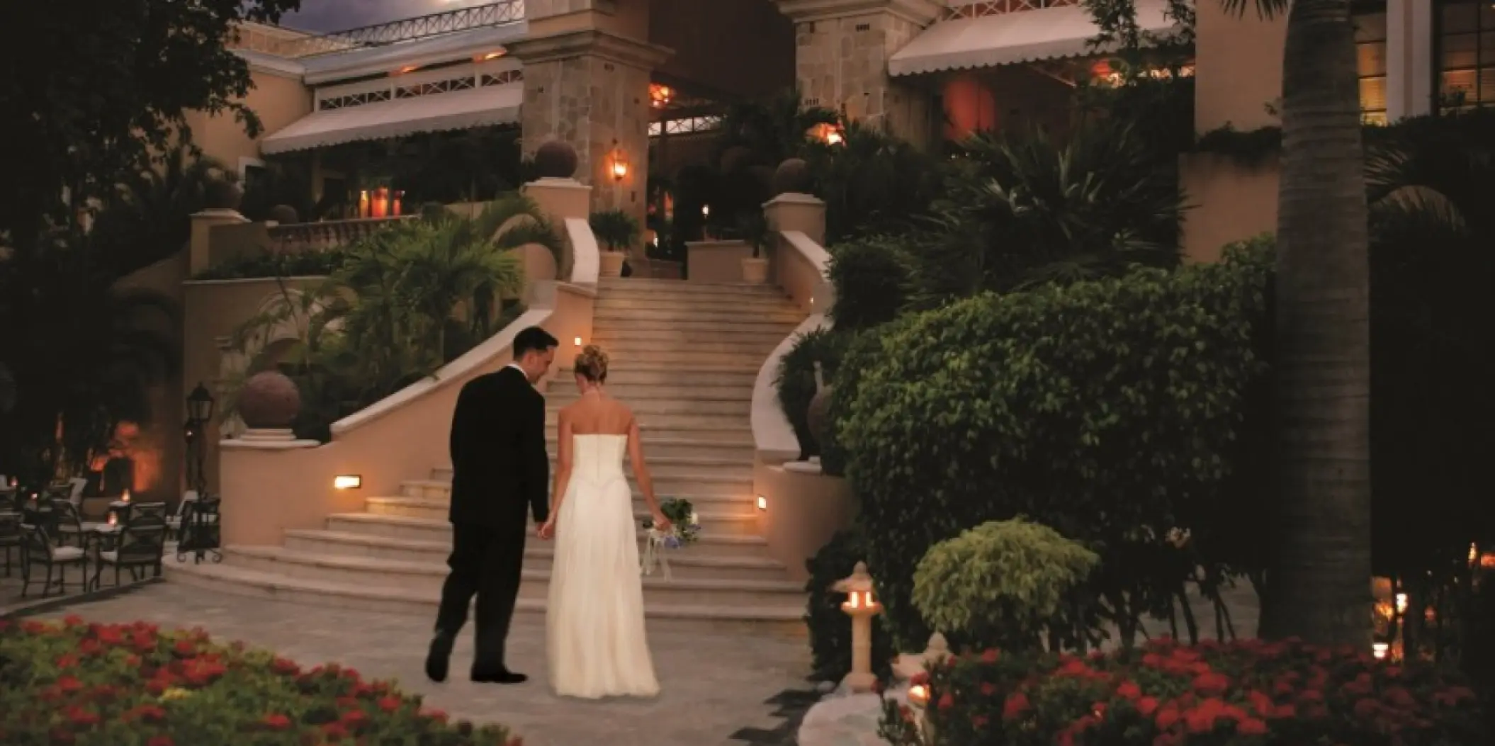 Bride and groom walking up the illuminated stone stairs at Royal Hideaway Playacar, Playa Del Carmen