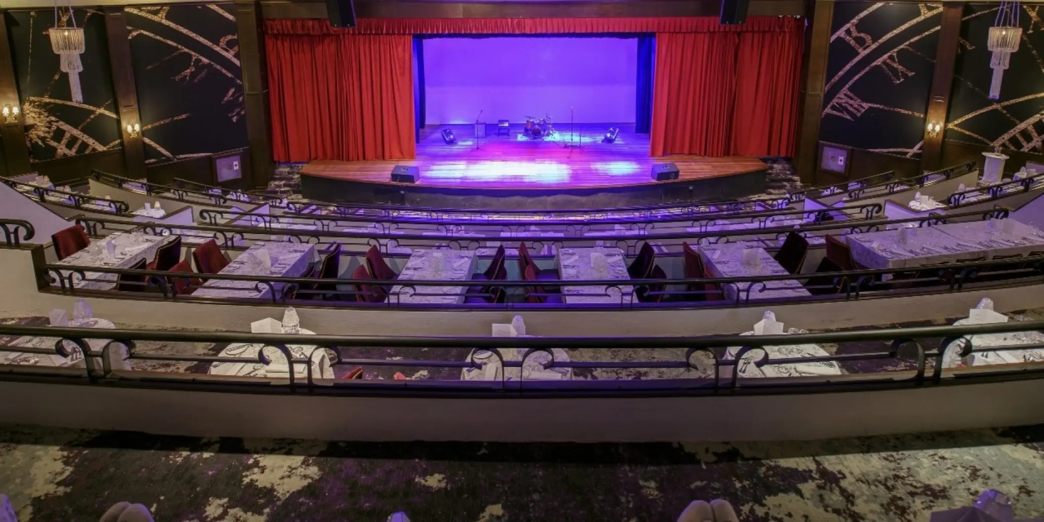 Indoor theater with tiered dinner seating and stage at Royal Hideaway Playacar, Playa Del Carmen