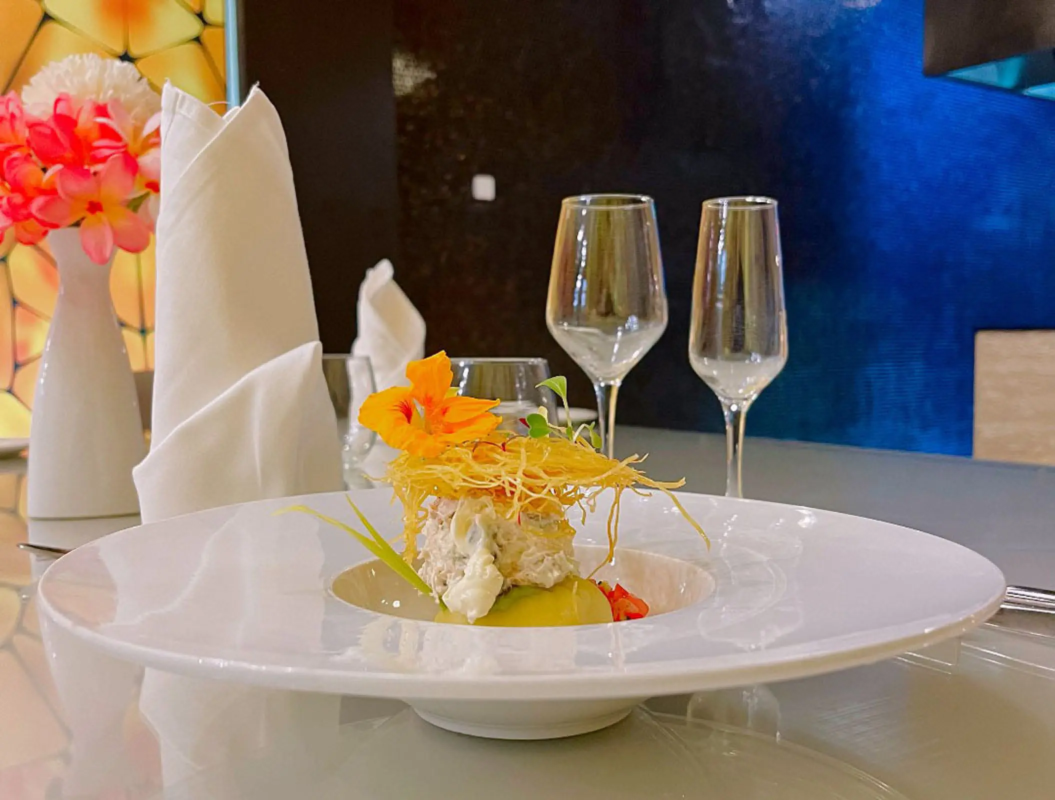 Gourmet plated appetizer with wine glasses at Royalton Blue Waters, Montego Bay