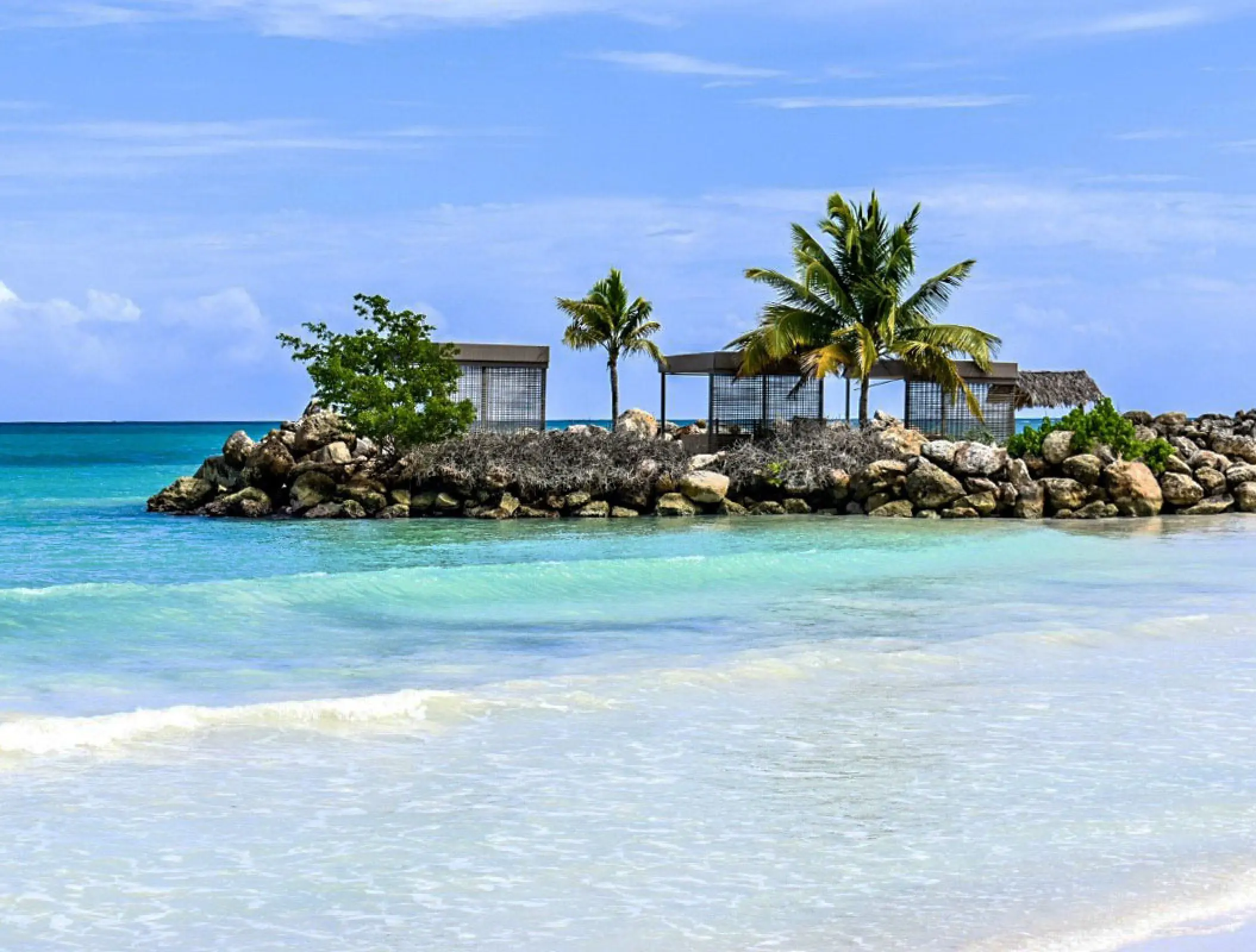 Royalton Blue Waters beachfront cabanas on a rocky jetty overlooking turquoise water, Montego Bay