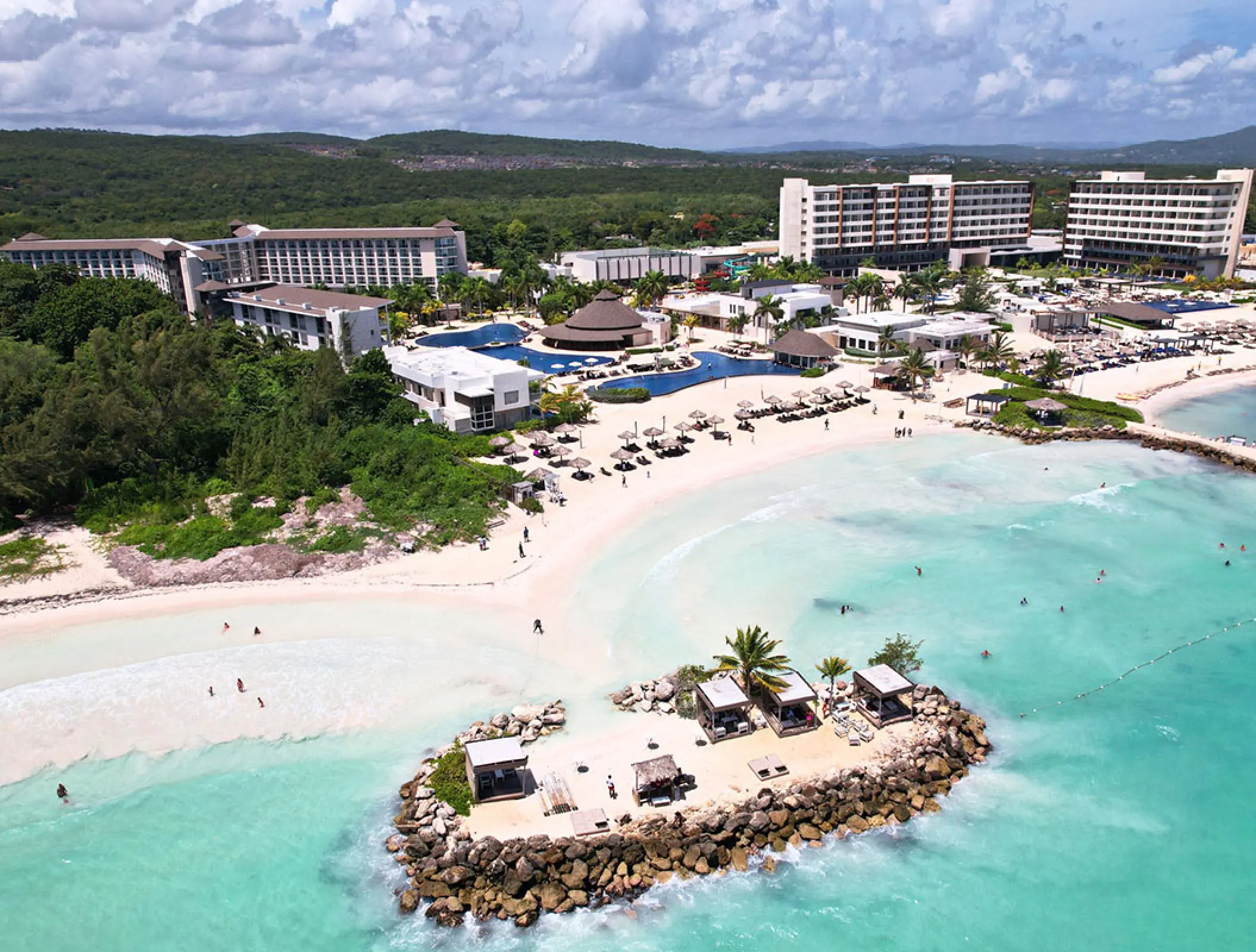 Aerial view of the beach, pools, and guest buildings at Royalton Blue Waters, Montego Bay