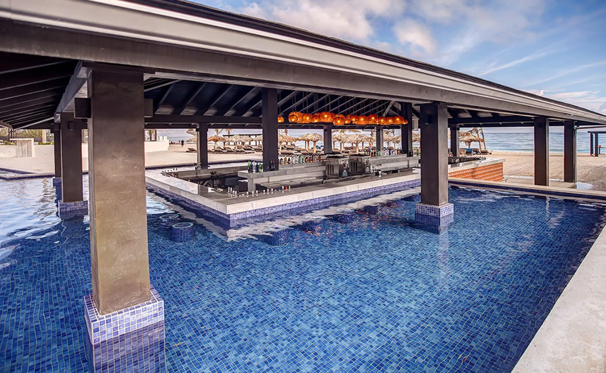 Swim-up pool bar under a dark wood pavilion at Royalton Blue Waters, Montego Bay