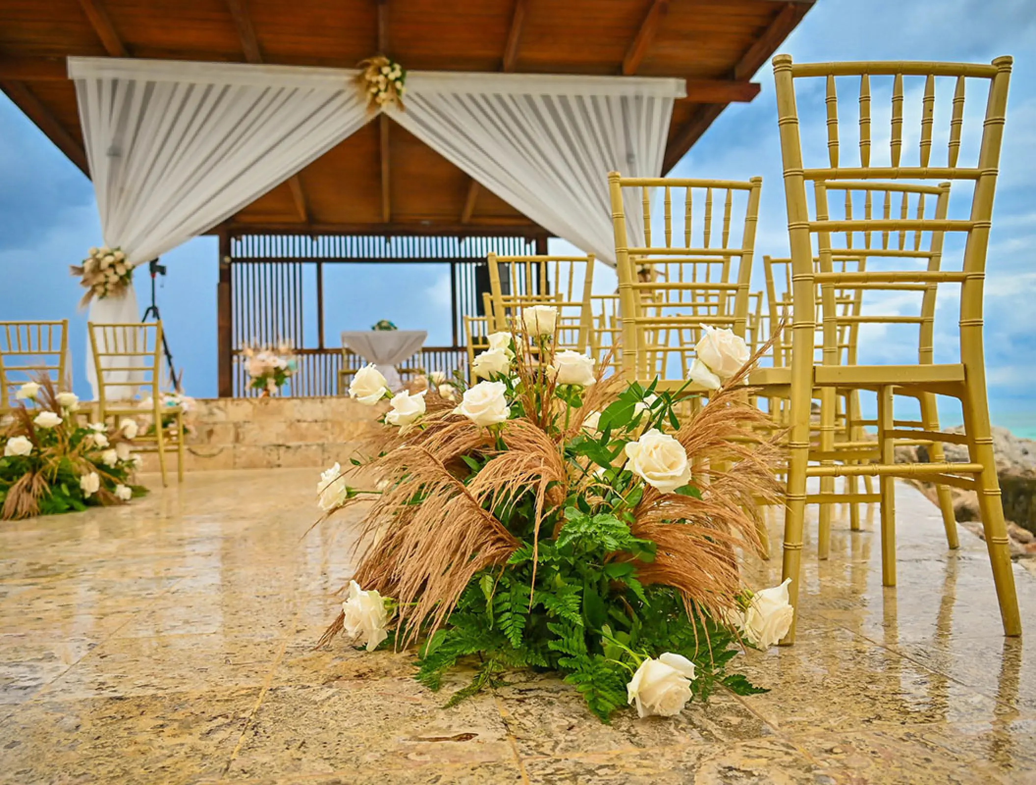 White rose floral arrangements and gold chairs for a wedding ceremony at Royalton Blue Waters, Montego Bay