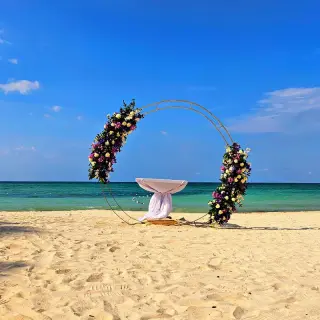 Circular floral wedding ceremony arch on the beach at Royalton Blue Waters, Montego Bay