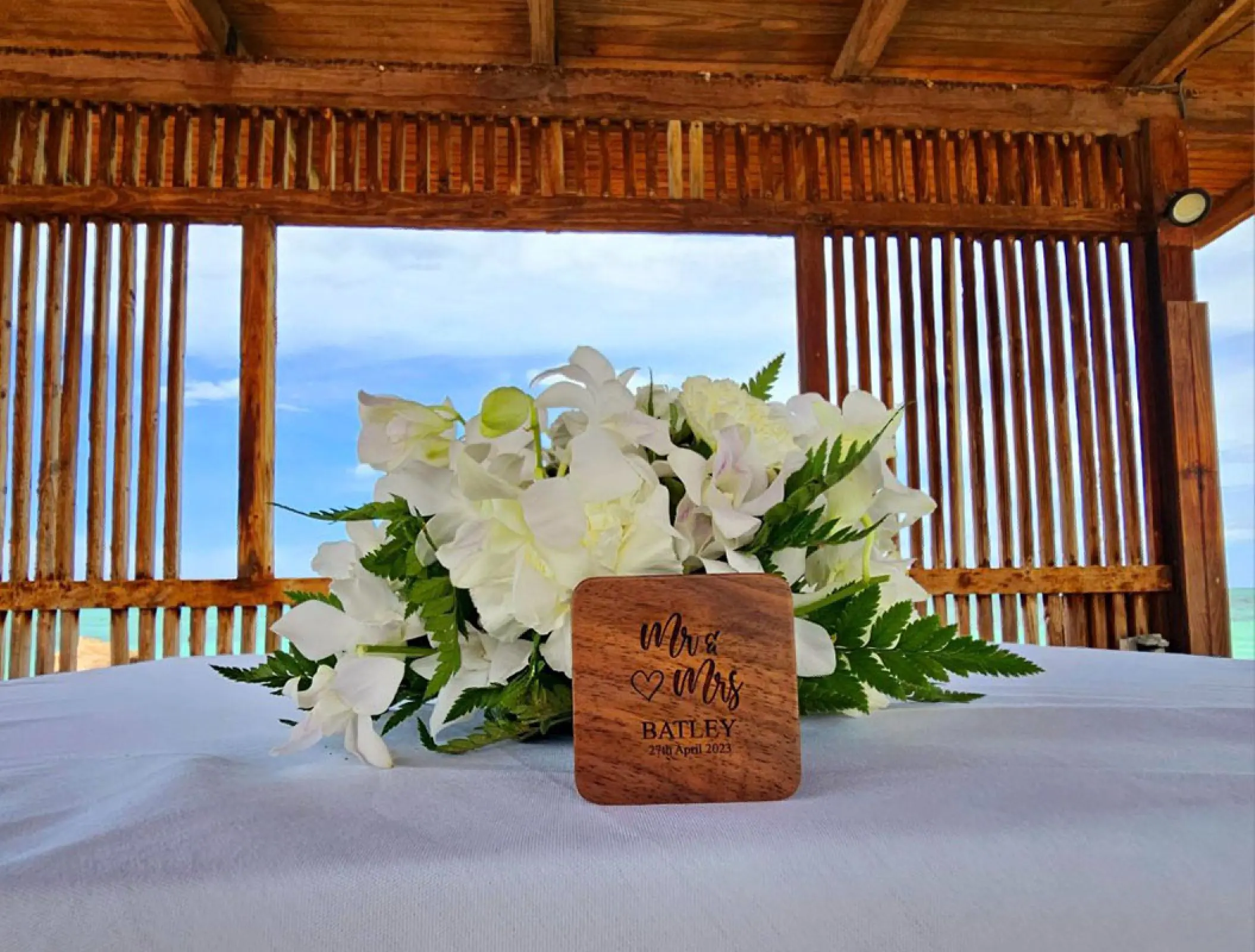 White orchid centerpiece and wooden Mr & Mrs sign for a wedding at Royalton Blue Waters, Montego Bay