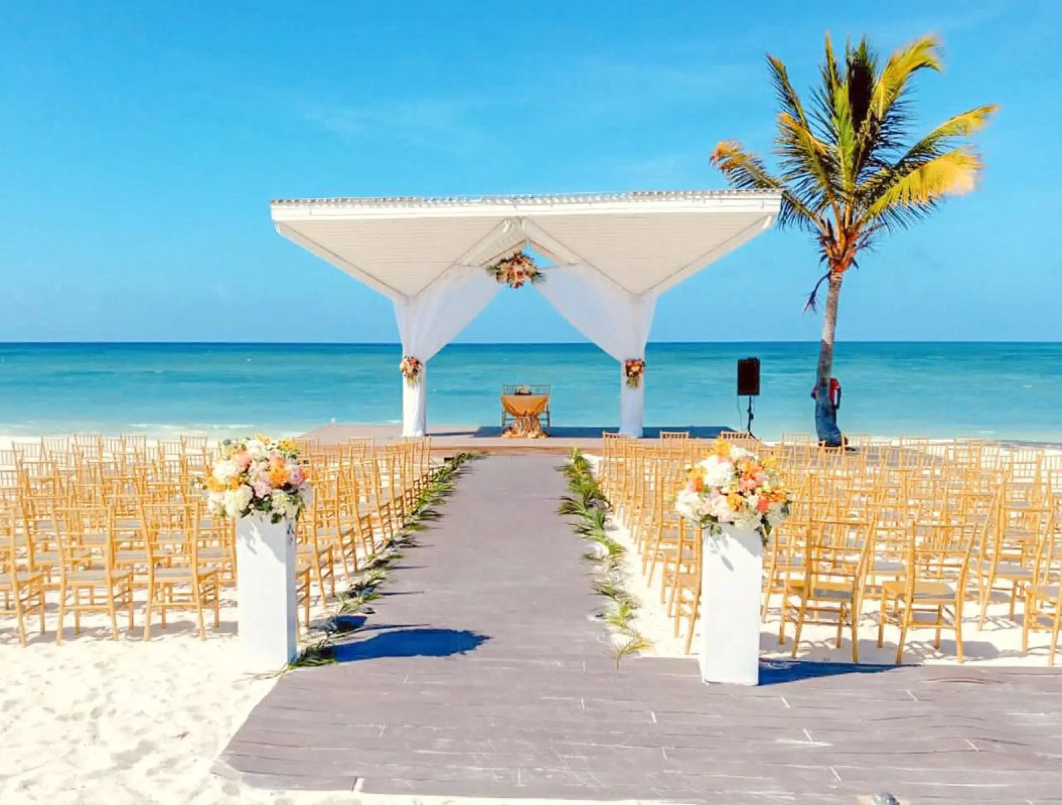 Beachfront wedding ceremony with white gazebo and gold chairs at Royalton Blue Waters, Montego Bay