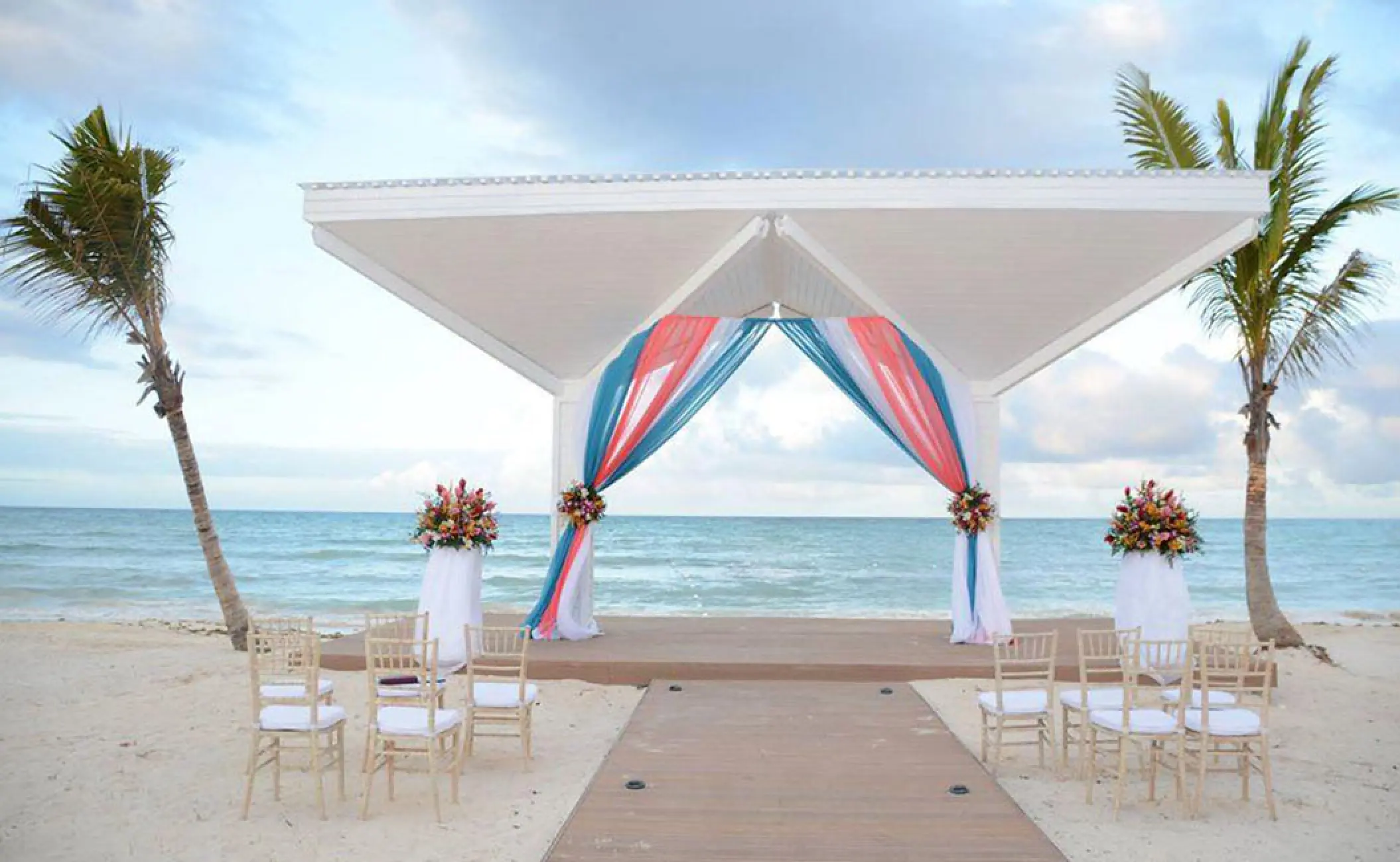 Beachfront wedding ceremony gazebo with coral and blue drapes at Royalton Blue Waters, Montego Bay