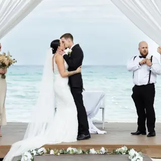 Bride and groom kissing during their beach ceremony at Royalton Blue Waters, Montego Bay