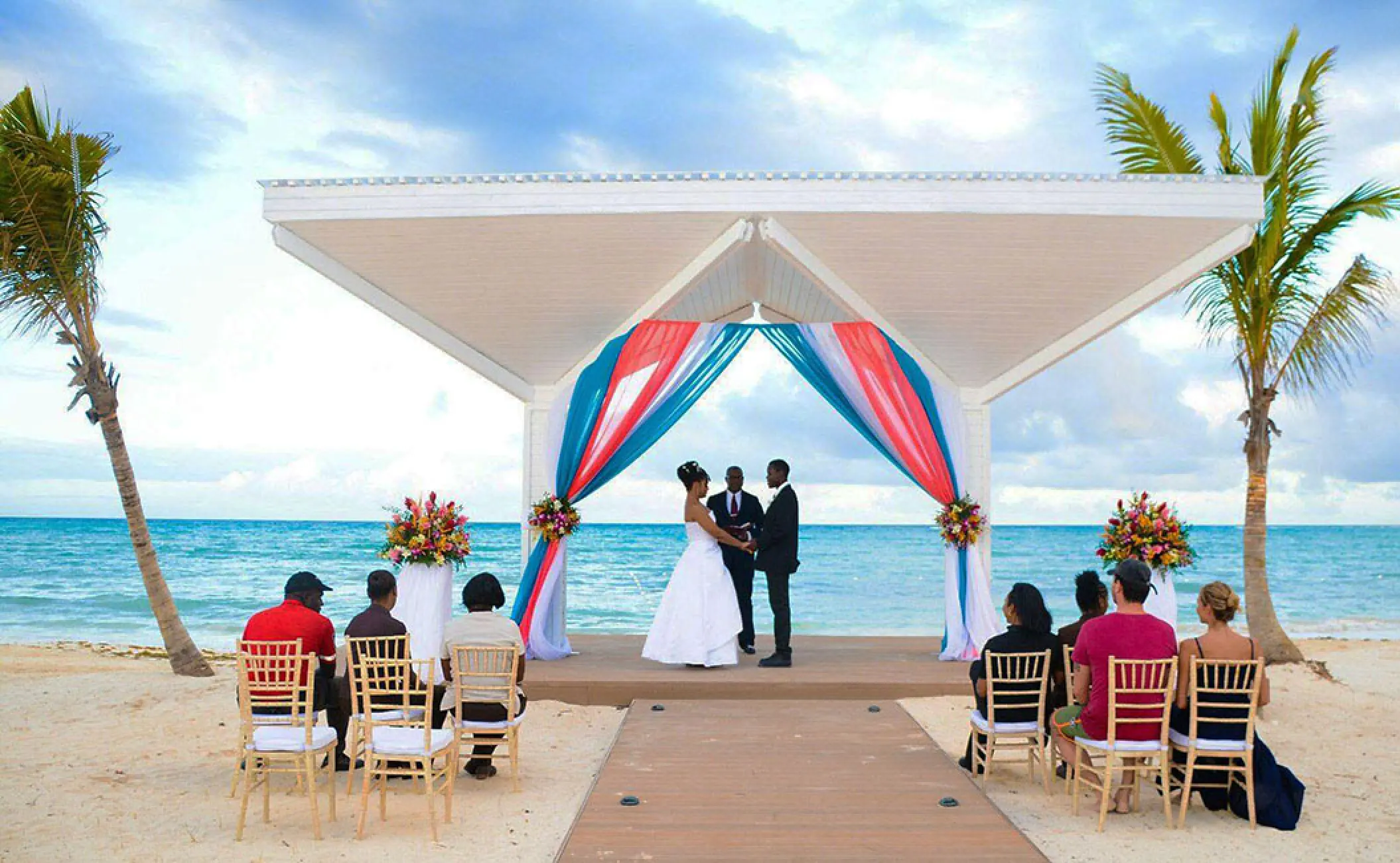 Beachfront wedding ceremony at Royalton Blue Waters under a white gazebo with colorful fabric, Montego Bay