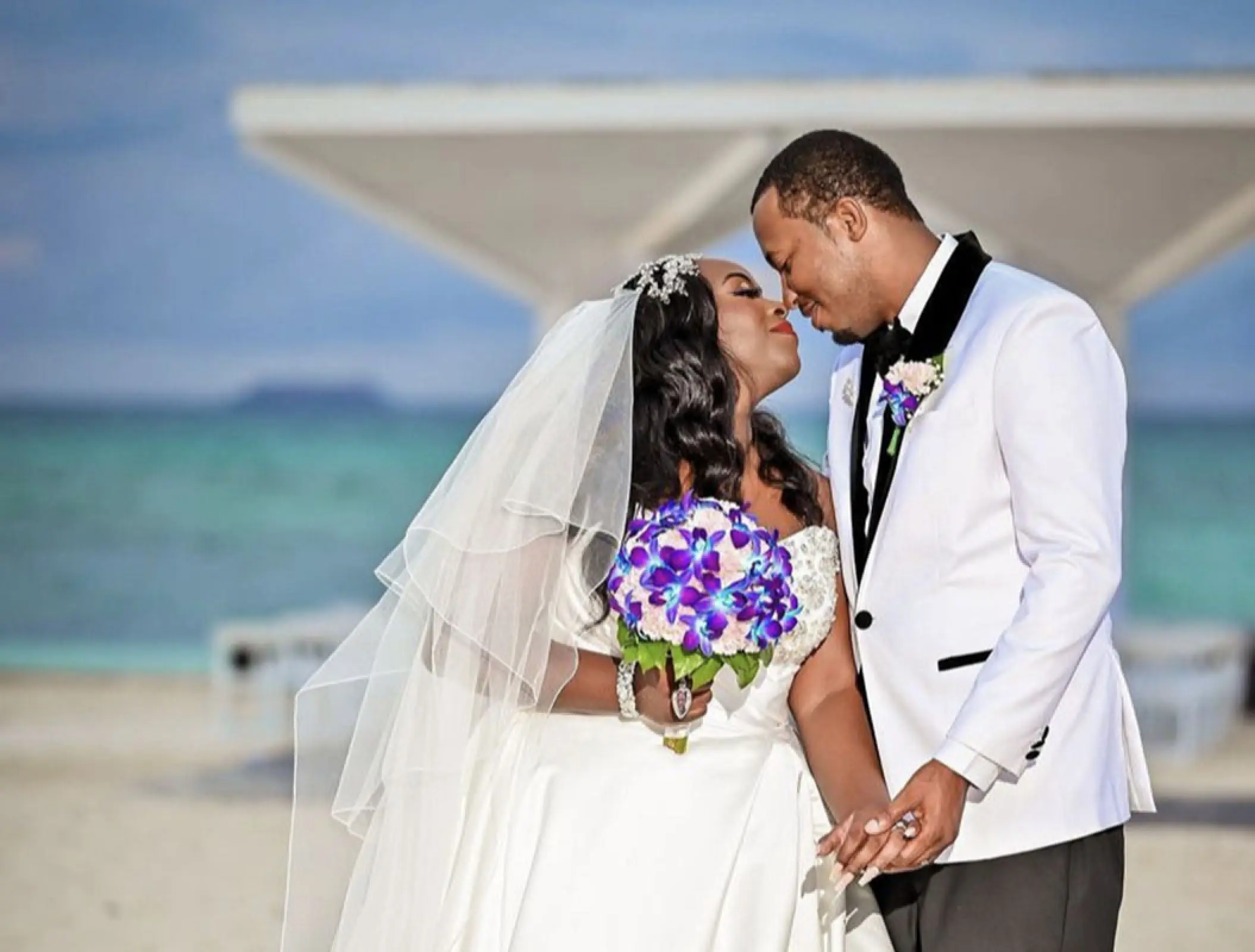 Newlyweds holding hands on the beach at Royalton Blue Waters, Montego Bay