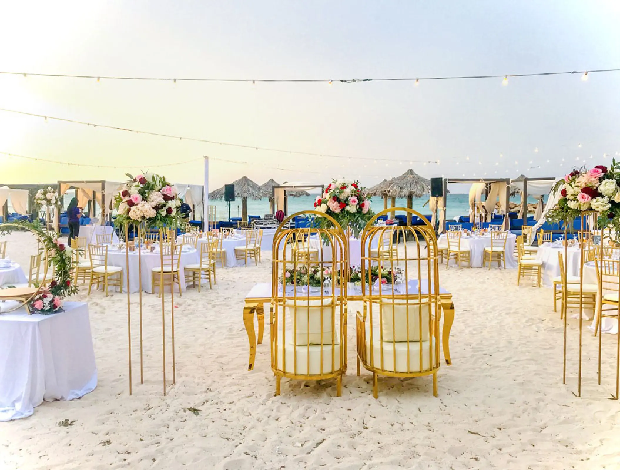 Beach wedding reception with gold cage chairs and floral centerpieces at Royalton Blue Waters, Montego Bay