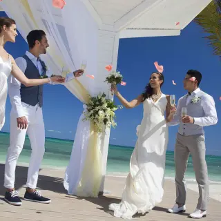 The bride, groom, and wedding party toasting at a beach ceremony, Royalton Blue Waters Montego Bay