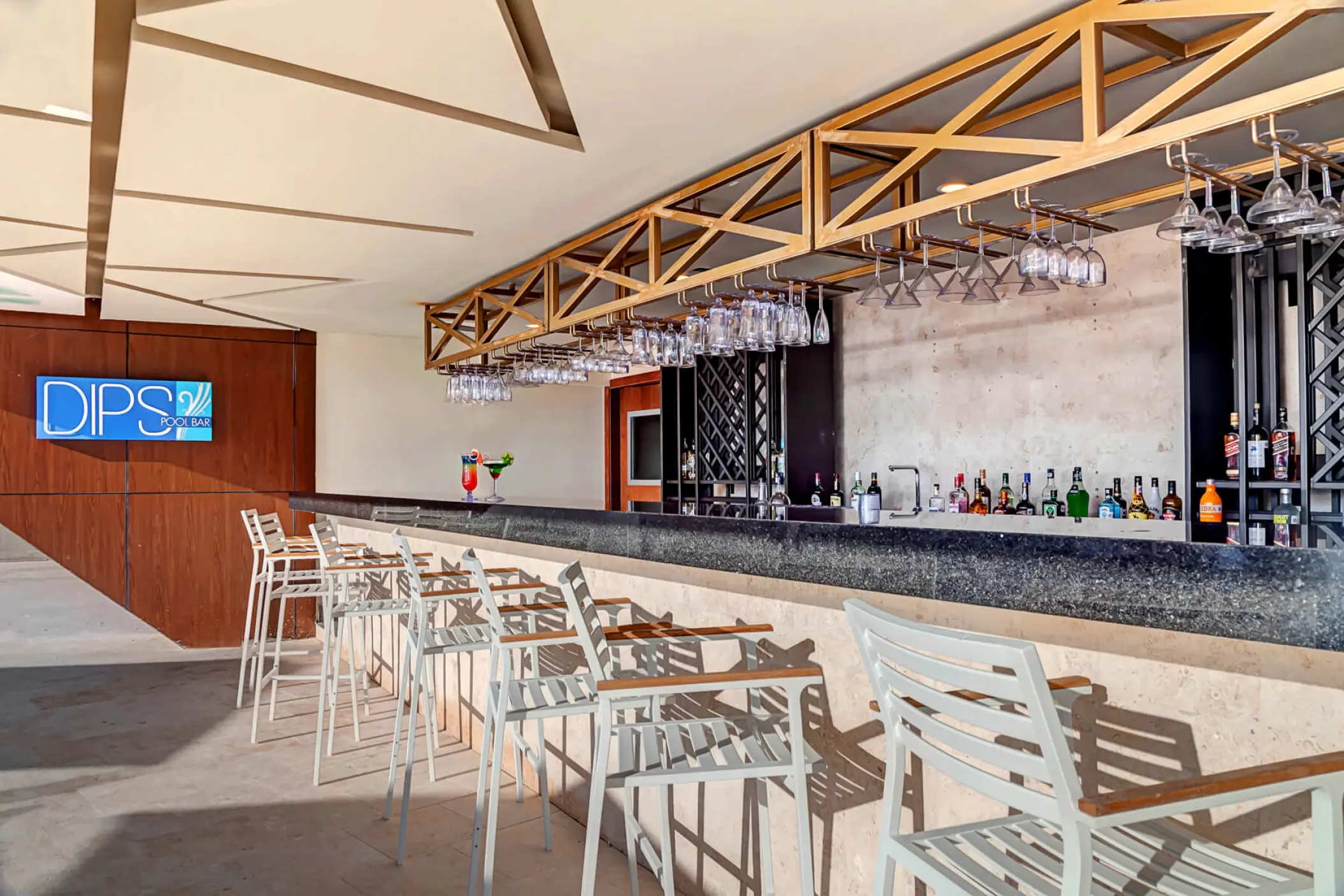 Modern Dips pool bar with white high-top seating at Royalton CHIC Cancun