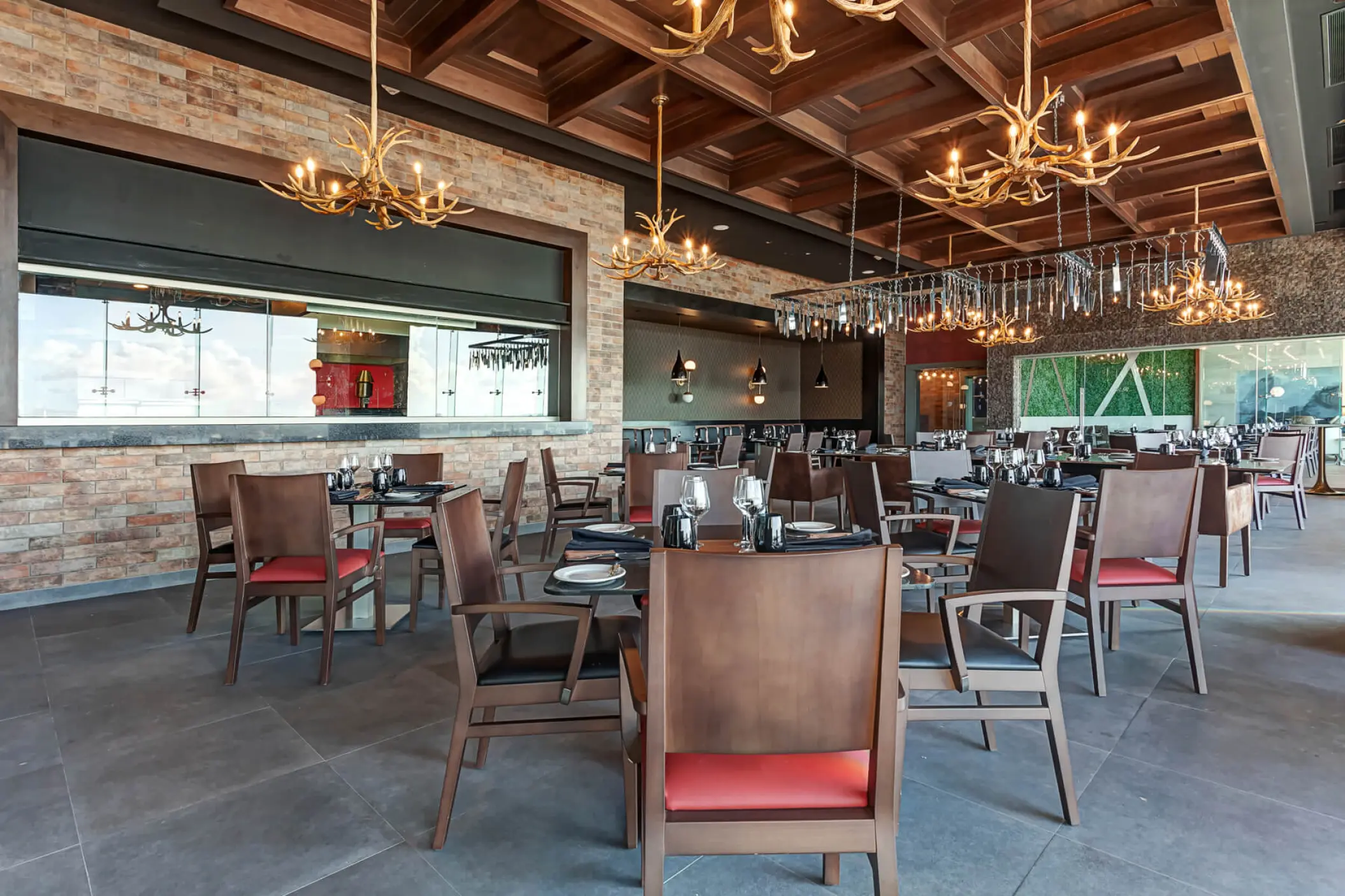 Modern steakhouse restaurant with antler chandeliers at Royalton CHIC Cancun
