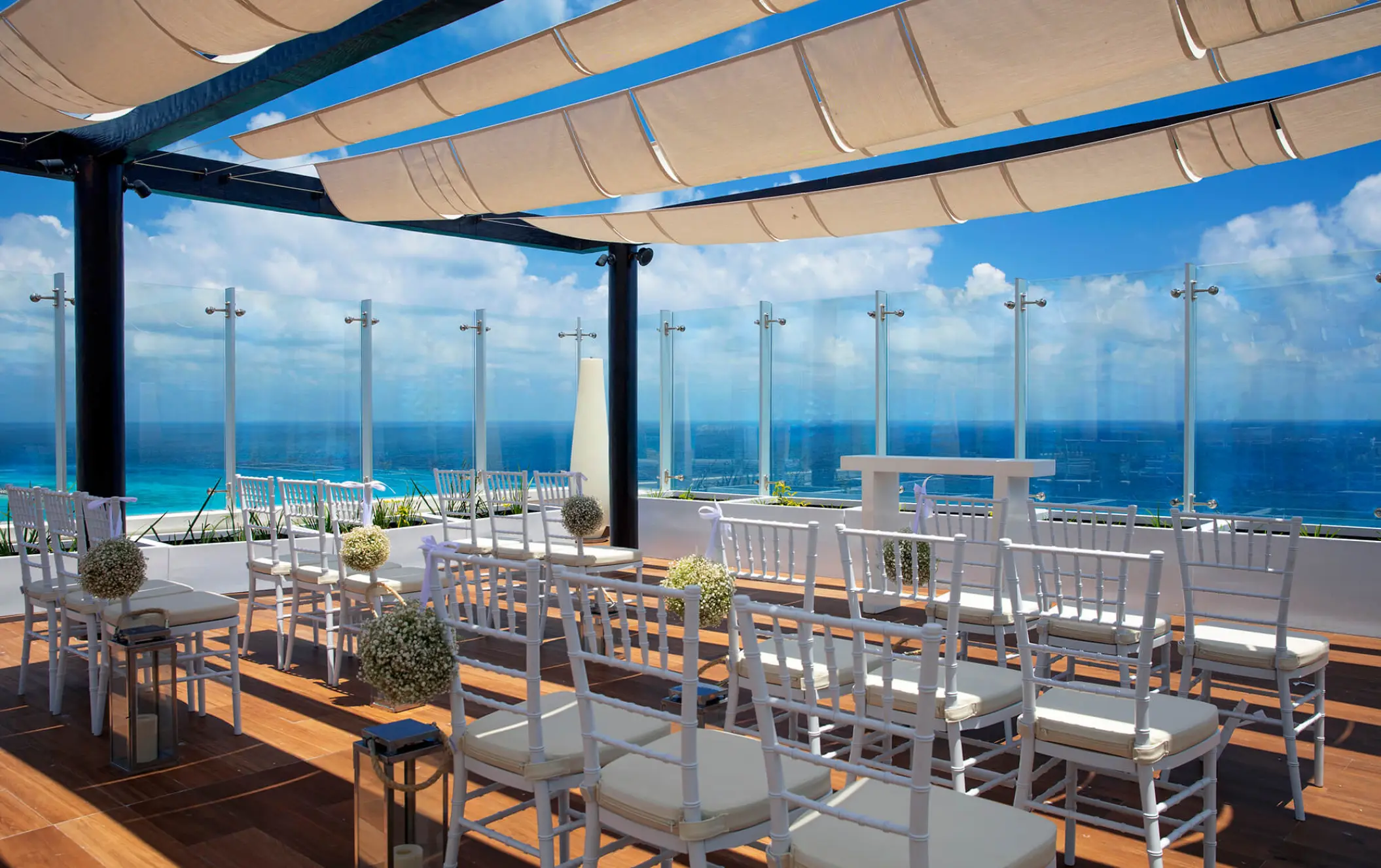 Sky terrace wedding ceremony with white chairs and ocean views at Royalton CHIC Cancun, Cancun