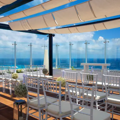 Sky terrace wedding ceremony with white chairs and ocean views at Royalton CHIC Cancun, Cancun