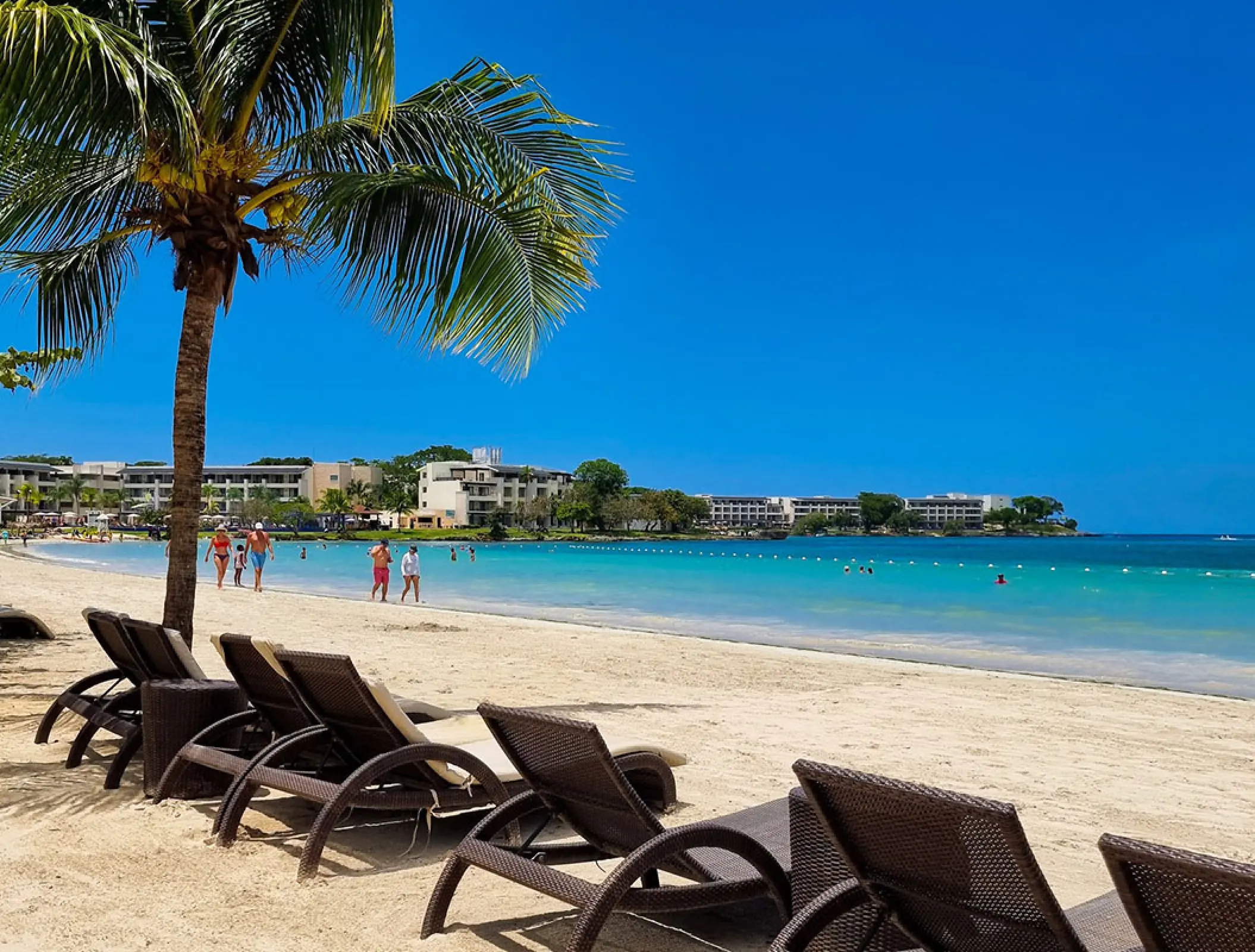 Row of lounge chairs on the white sand beach at Royalton Negril, Jamaica