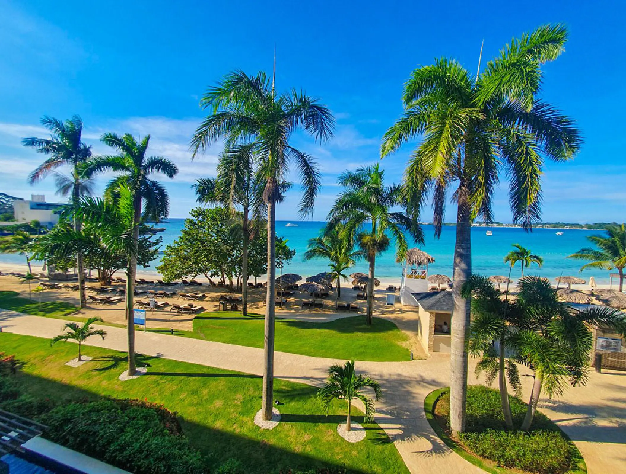 Palm trees and manicured gardens overlooking the beach at Royalton Negril, Negril