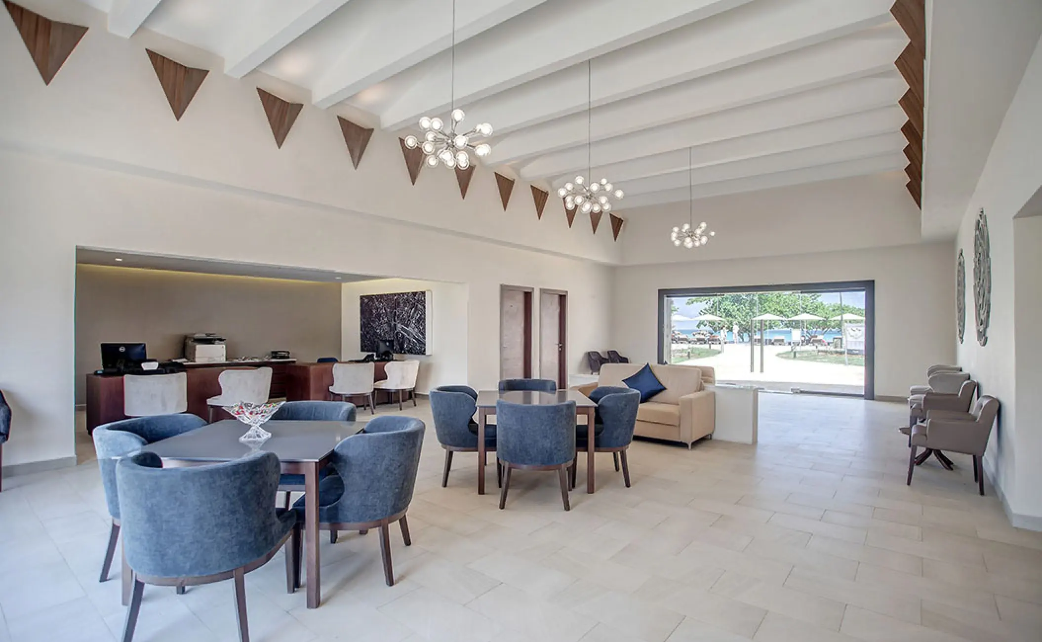 Modern hotel lobby with blue armchairs and white beamed ceilings at Royalton Negril, Jamaica