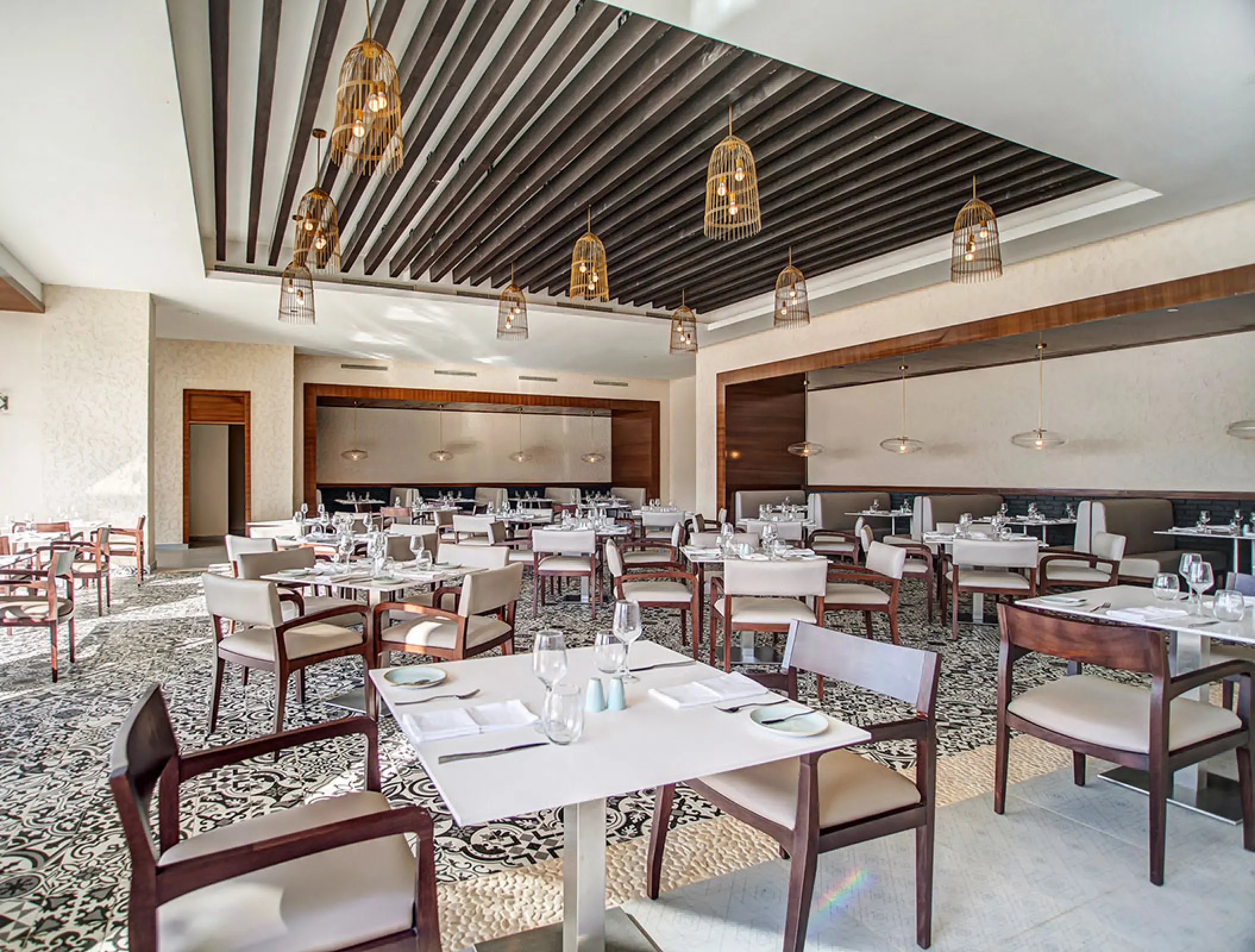 Modern restaurant dining room with birdcage pendant lights at Royalton Negril, Negril