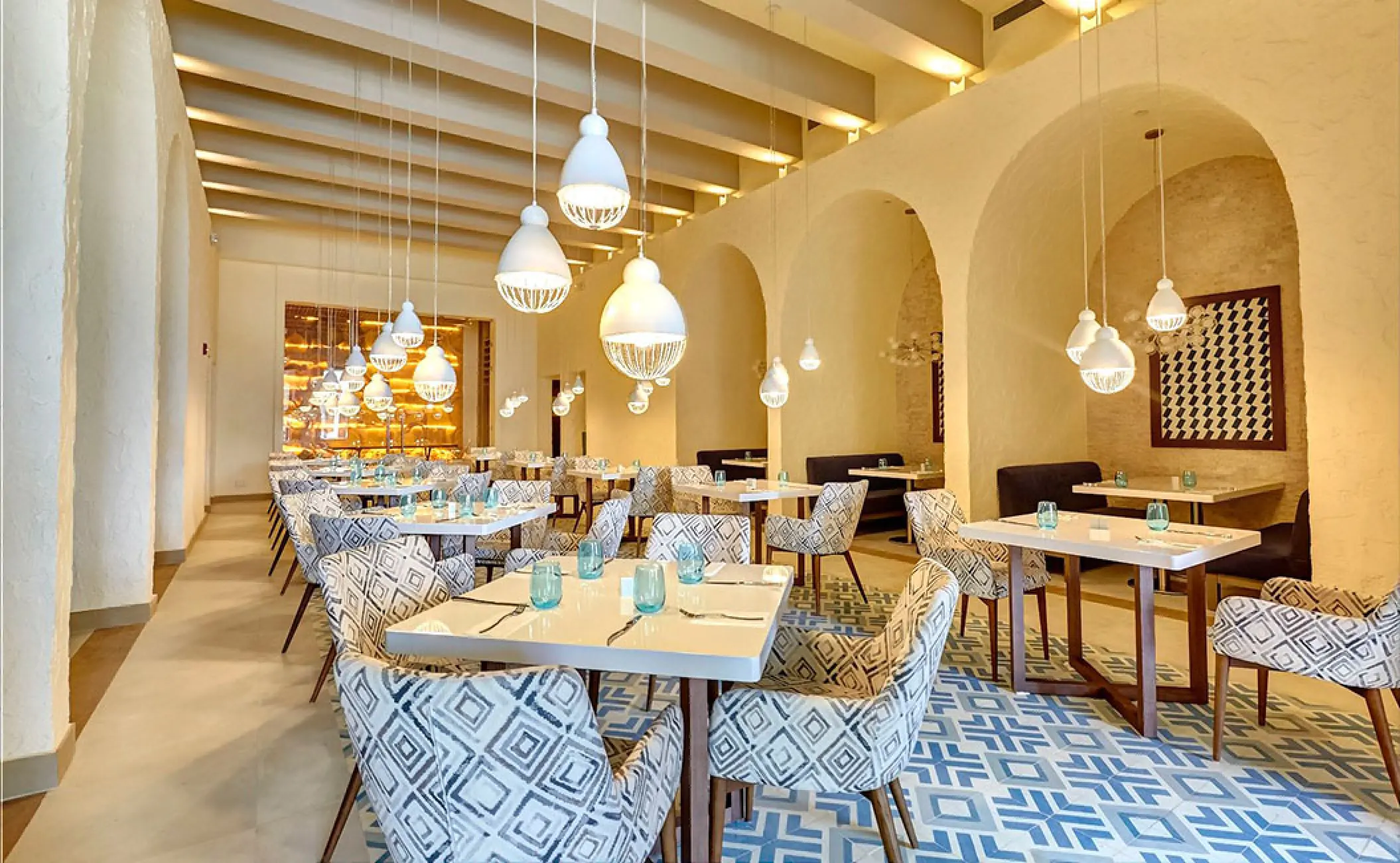 Modern restaurant dining room with arched walls and pendant lights at Royalton Negril, Negril