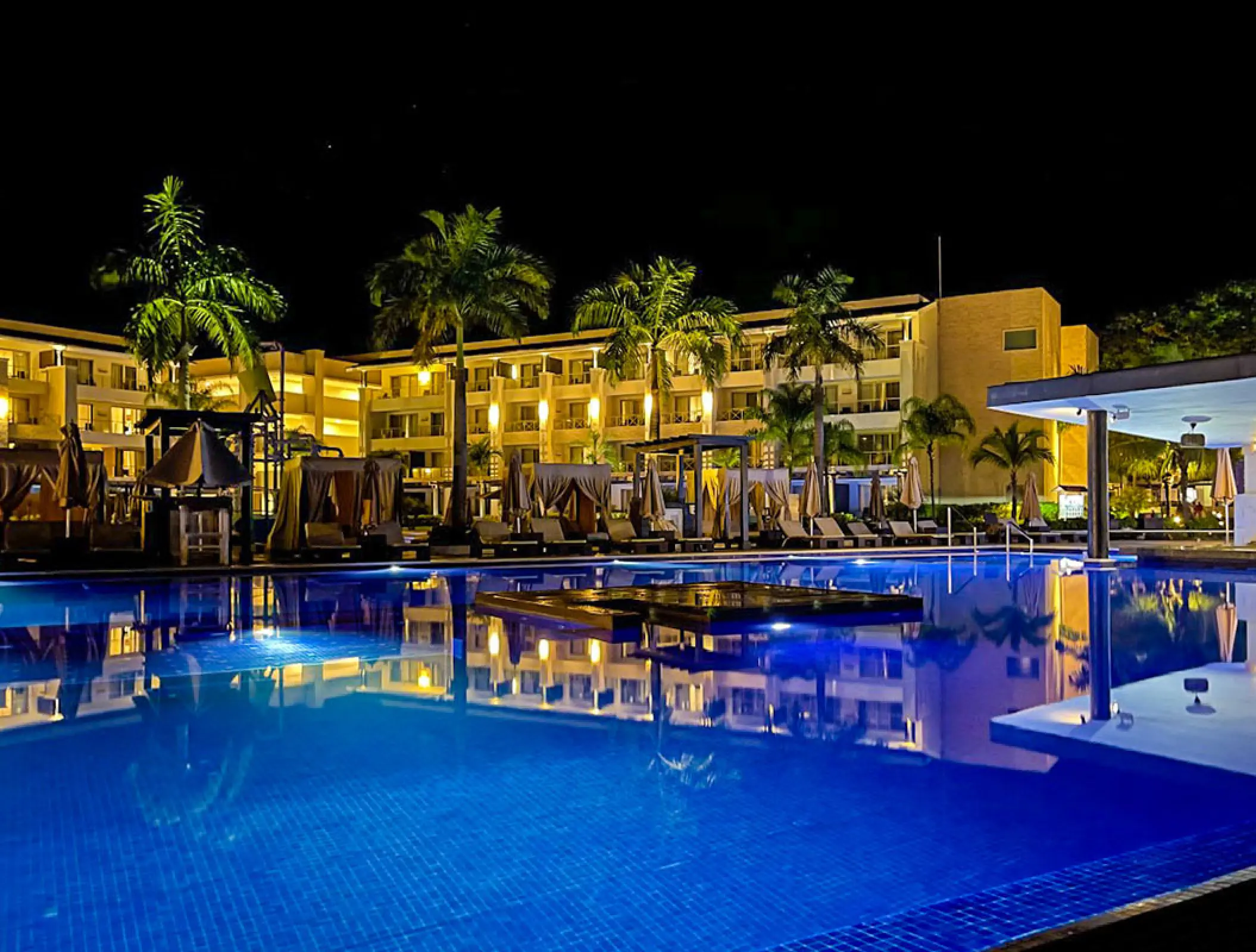 Illuminated swimming pool and resort buildings at night at Royalton Negril, Negril