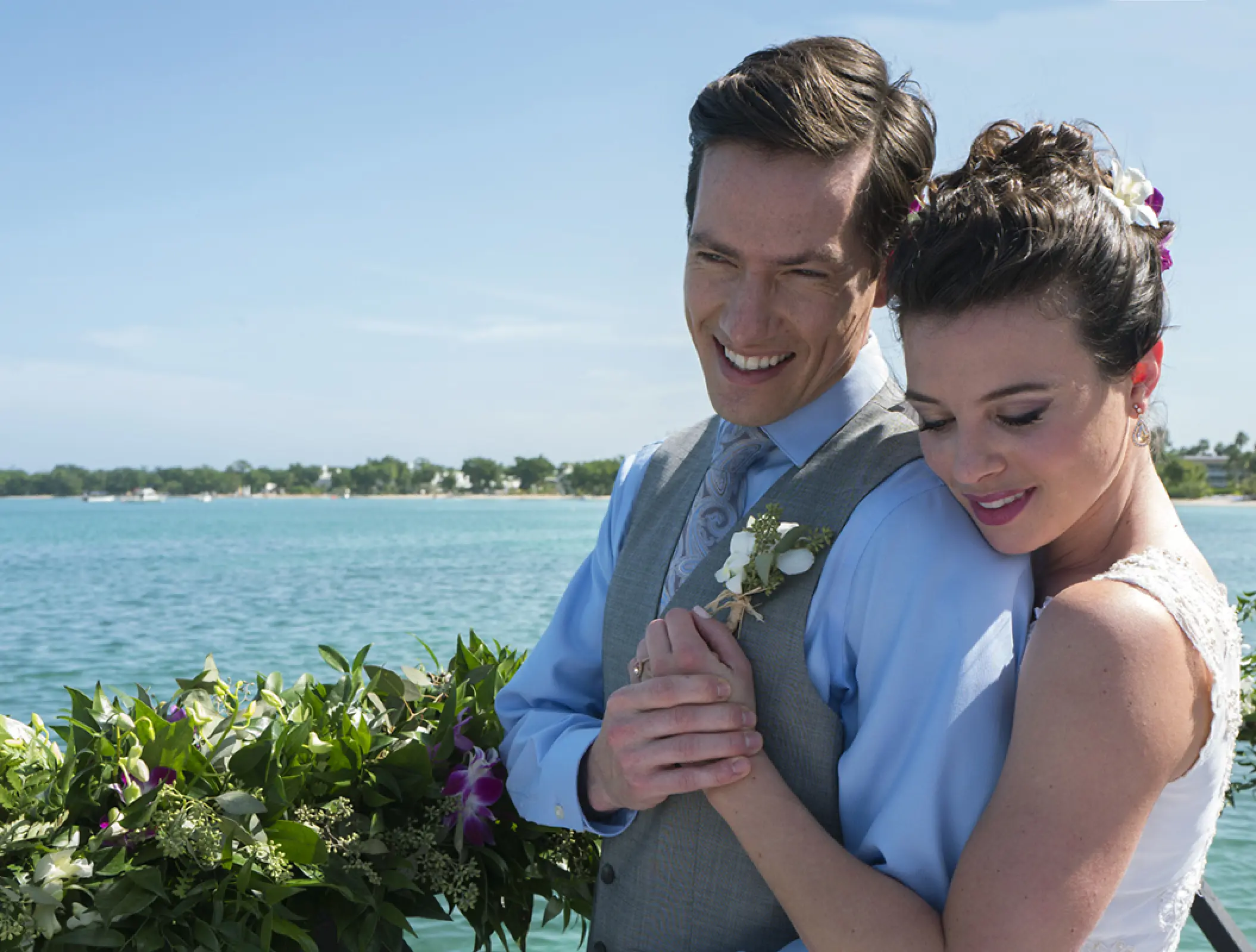 Bride embracing the groom by the ocean at Royalton Negril, Negril