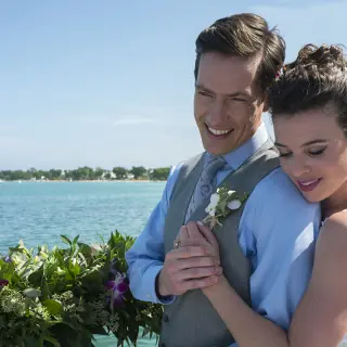 Bride embracing the groom by the ocean at Royalton Negril, Negril