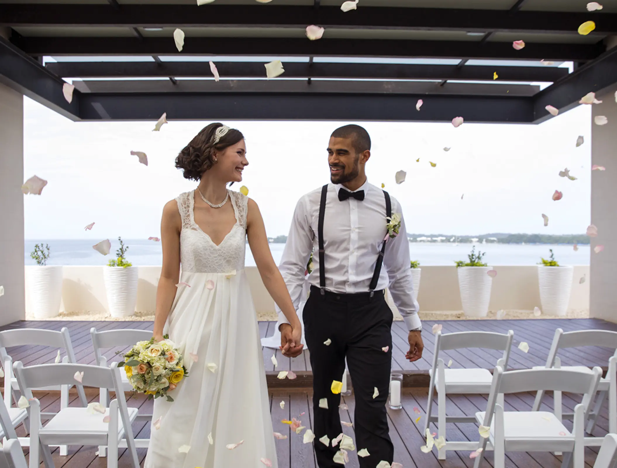 Bride and groom walking down the aisle under falling petals at Royalton Negril, Negril