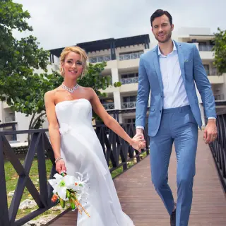 Bride and groom walking across a wooden bridge at Royalton Negril, Negril