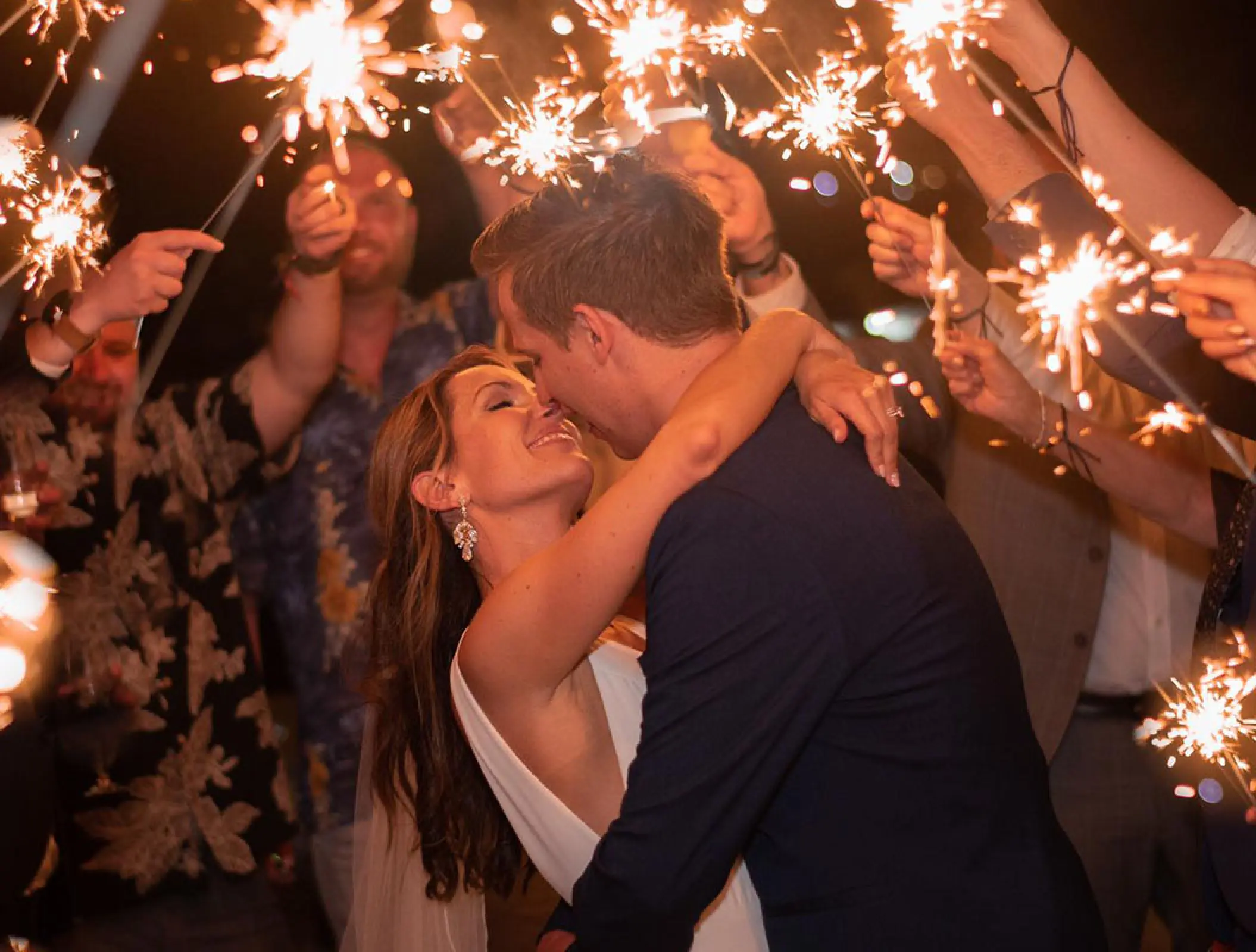Newlyweds kissing during a sparkler send-off at Royalton Negril, Negril